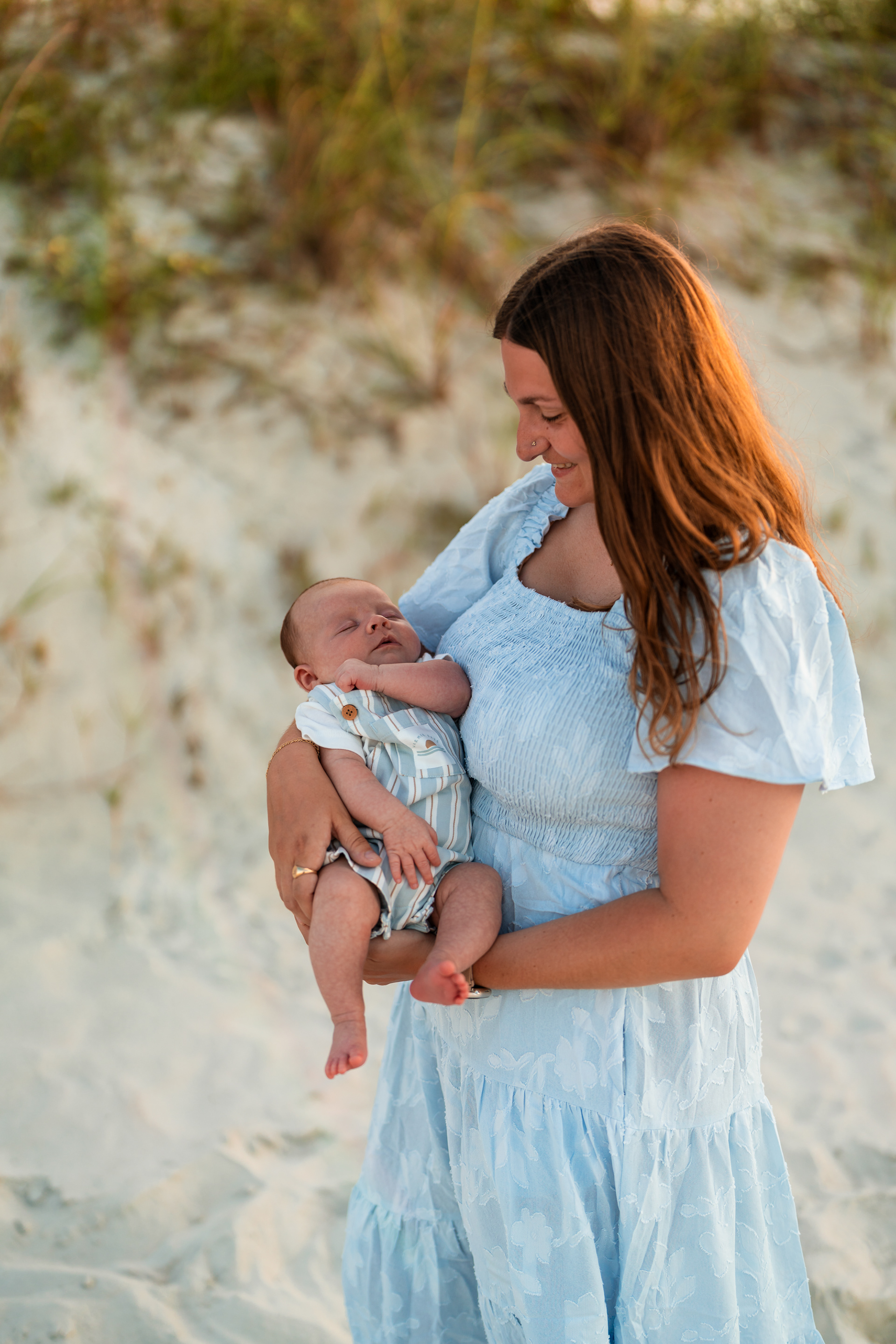 Mother looking down at her baby during a Ponce Inlet beach family photography session.