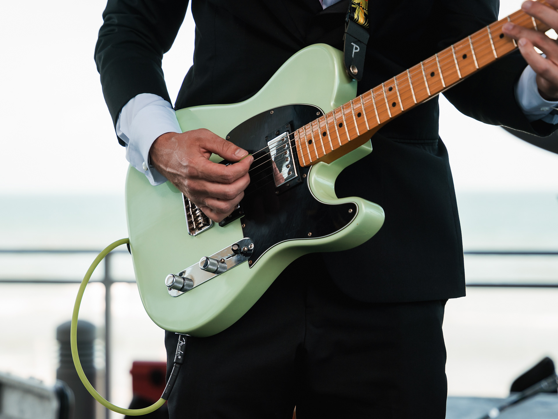 Close up of the groom playing guitar during a Daytona Beach wedding ceremony.