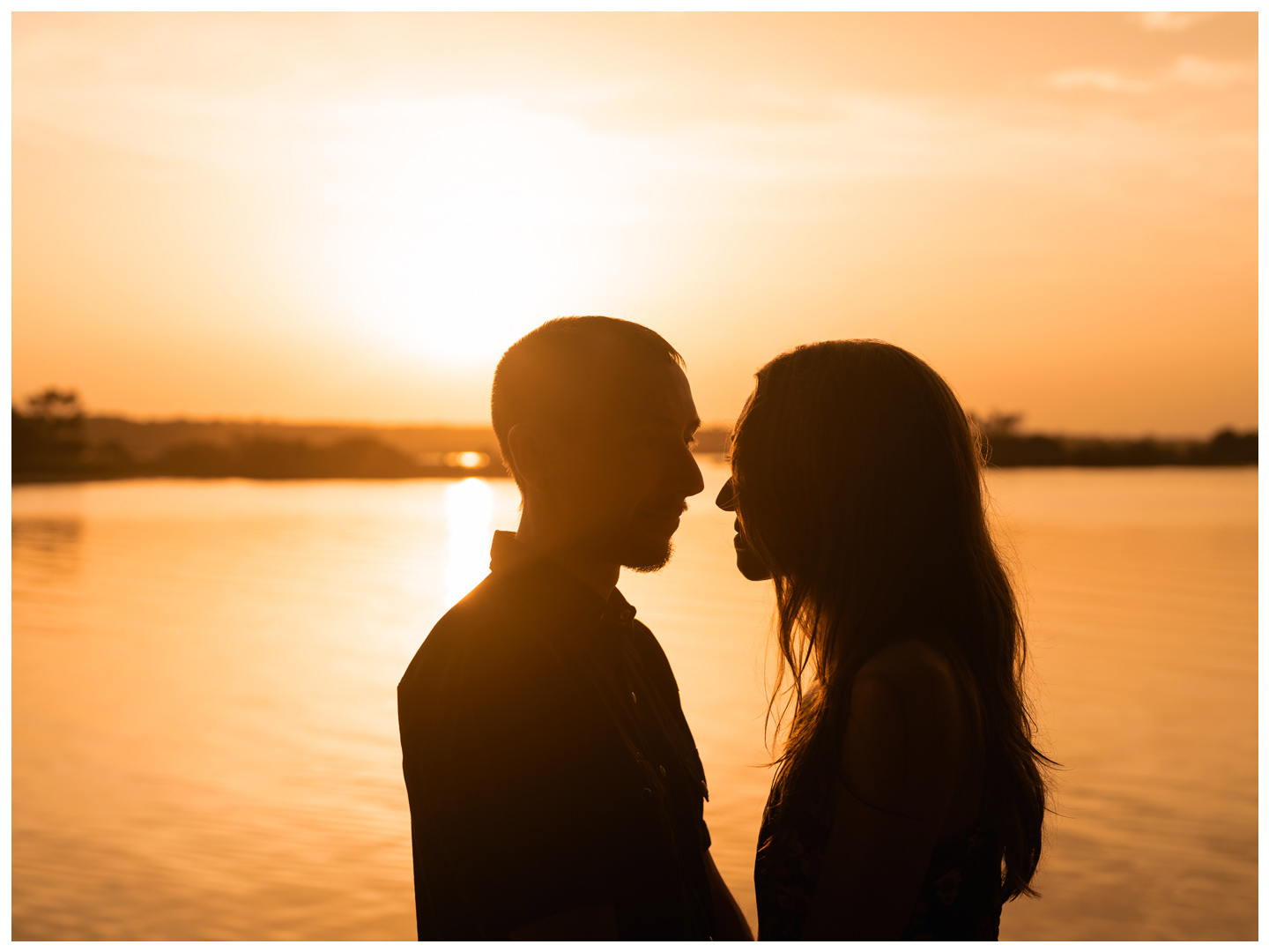 Close silhouette portraits of a couple facing one another with the sunset behind them at Washington Oaks.