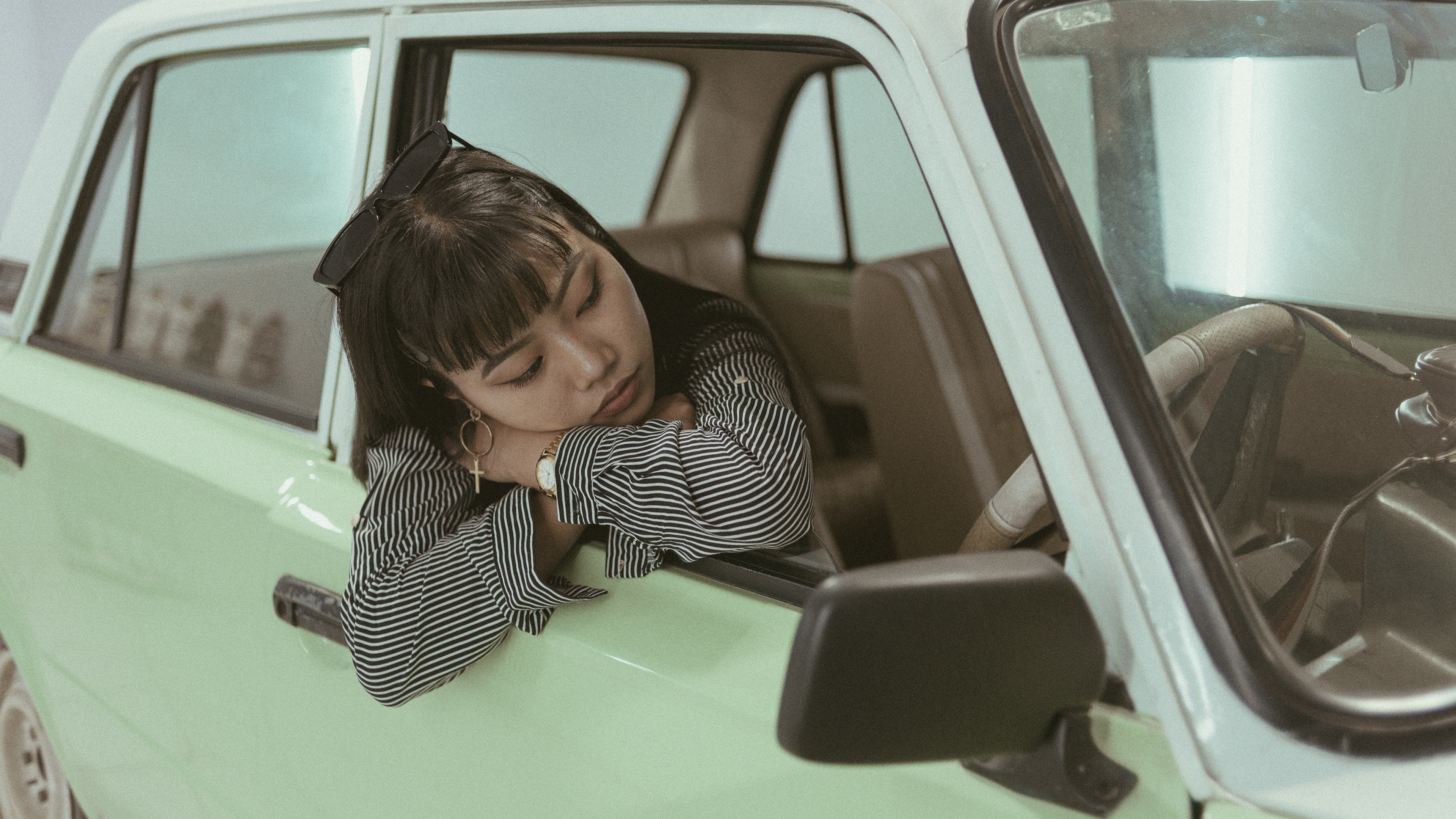 "Mysterious retro-themed image featuring a contemplative modern woman in a car, evoking a sense of nostalgia and introspection."