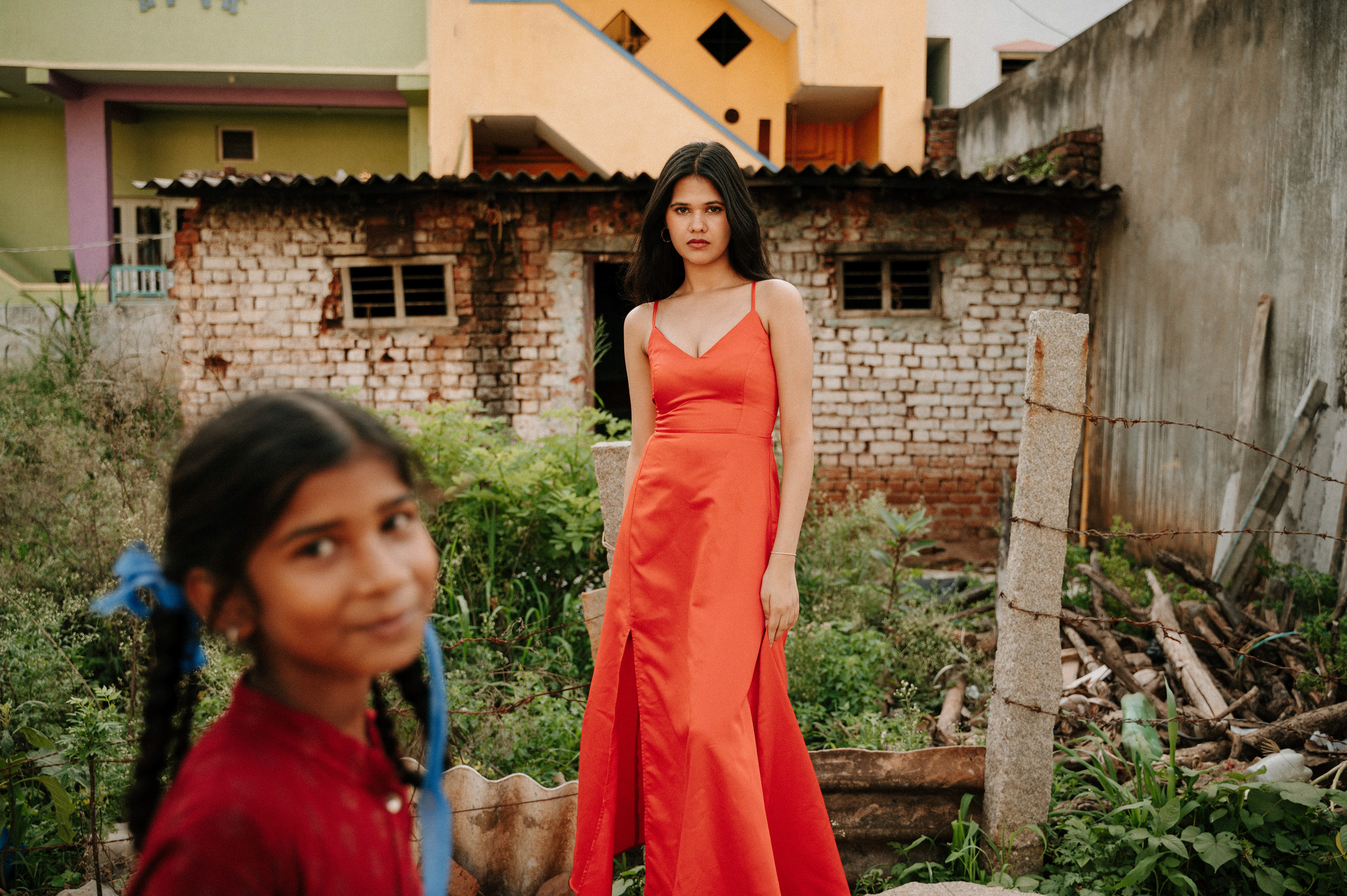 "Fashion photography in a rural setting: A girl in a vibrant red dress symbolizes the harmonious blend of modern and rural cultures, embodying two distinct aspects of life."