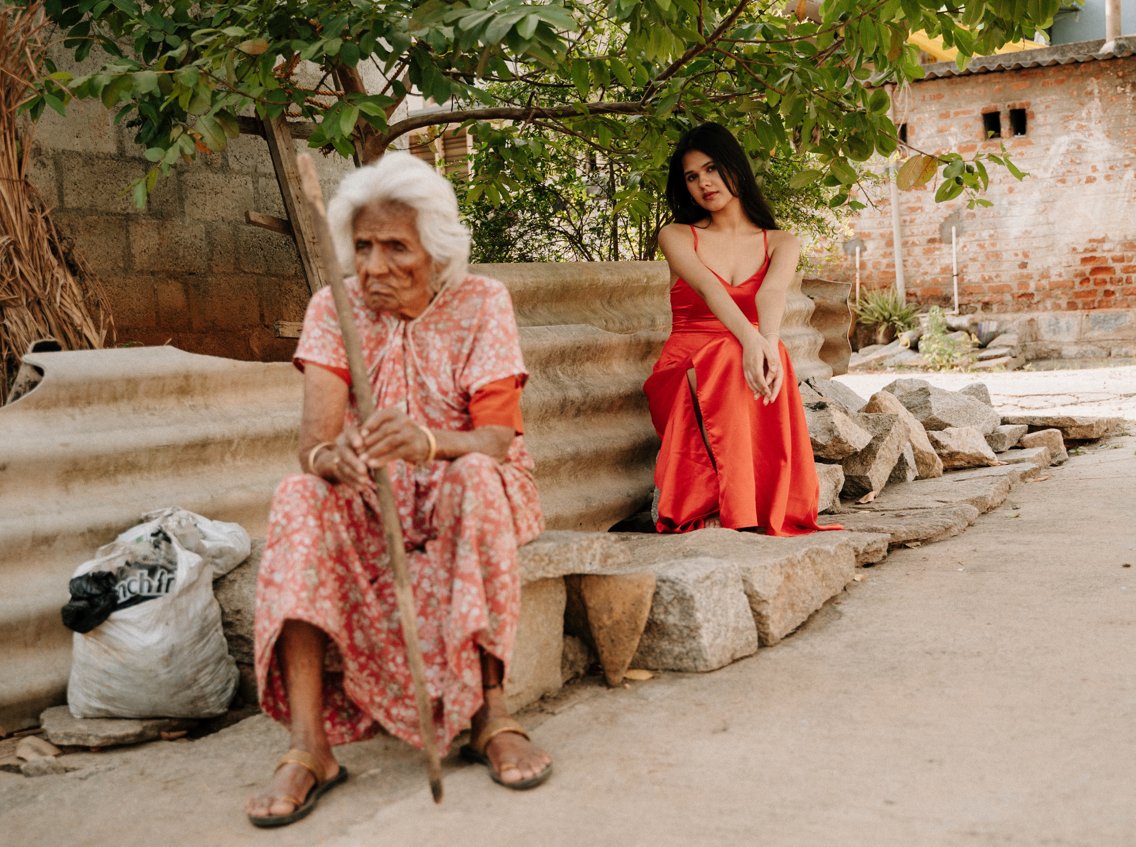 "Fashion photography in a rural setting: A girl in a vibrant red dress symbolizes the harmonious blend of modern and rural cultures, embodying two distinct aspects of life."