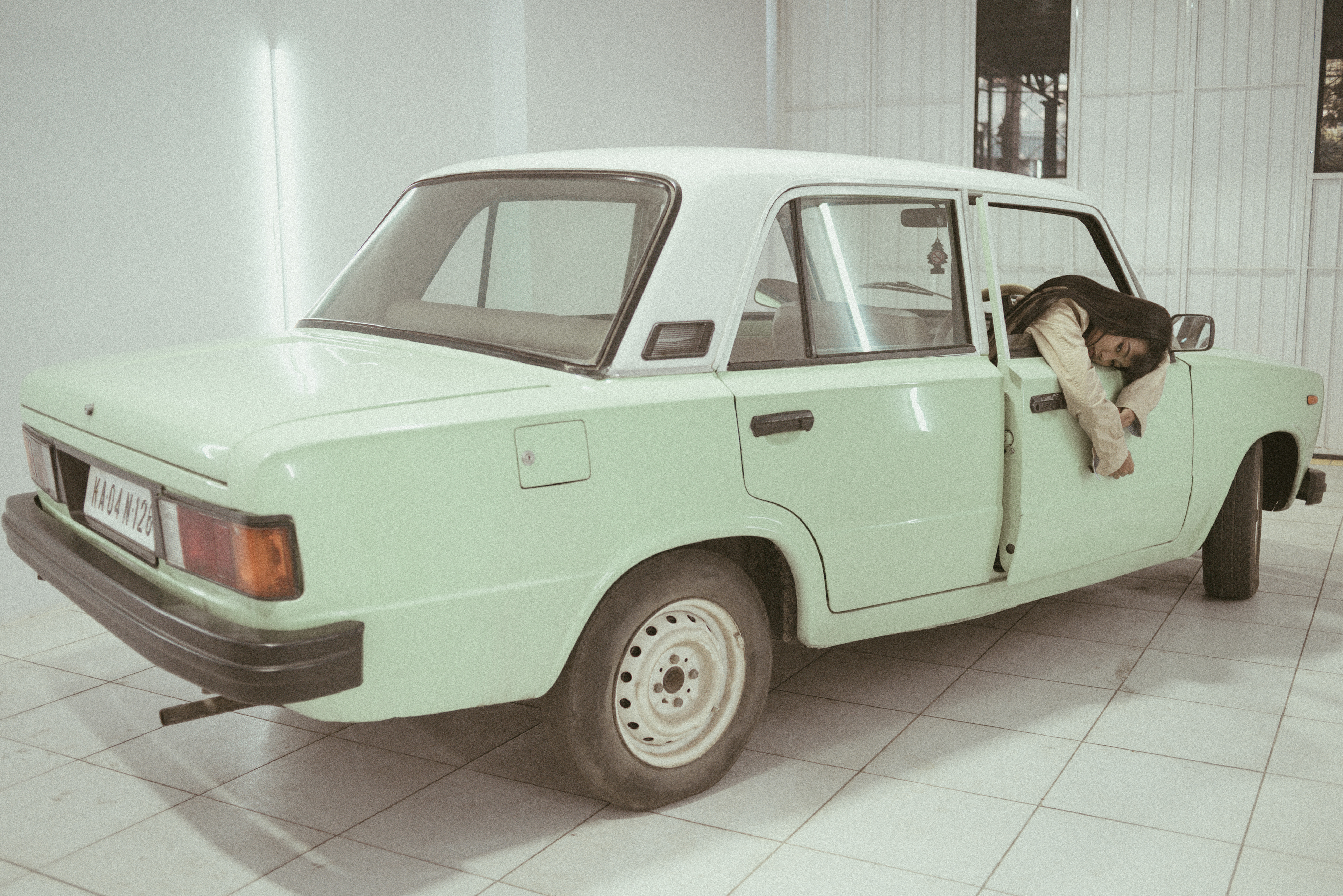 "Mysterious retro-themed image featuring a contemplative modern woman in a car, evoking a sense of nostalgia and introspection."