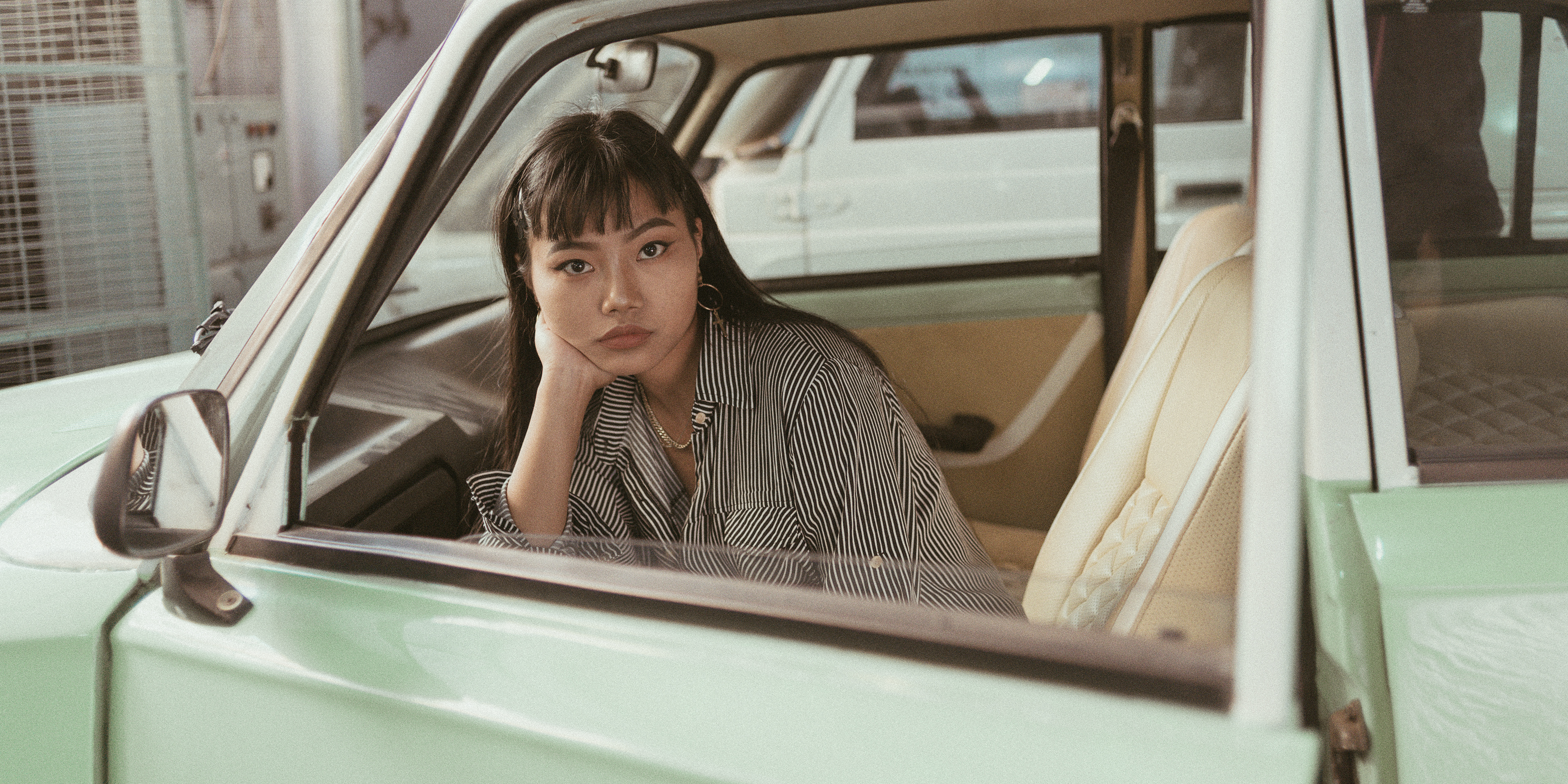 "Mysterious retro-themed image featuring a contemplative modern woman in a car, evoking a sense of nostalgia and introspection."