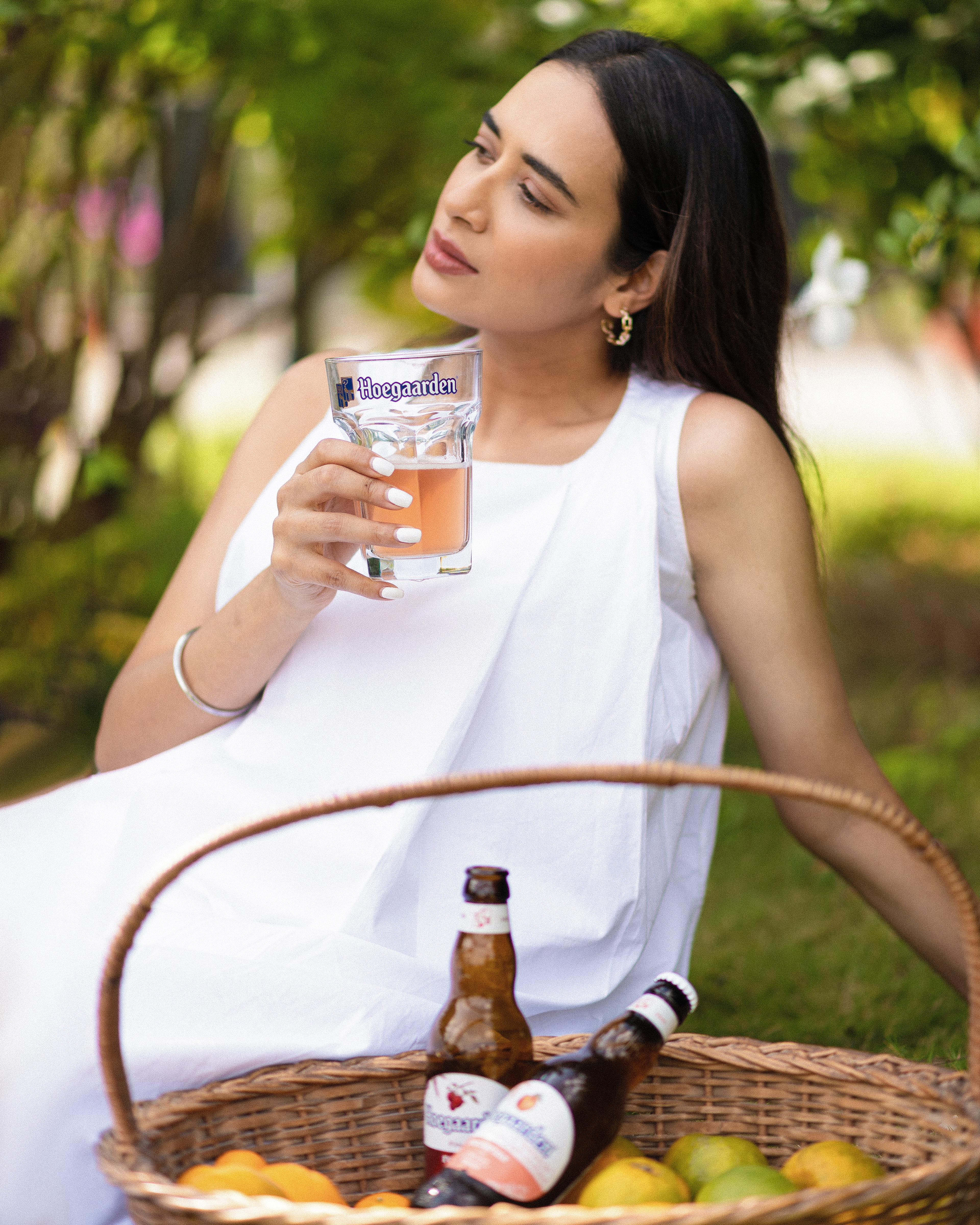 "Hoegaarden beer bottle surrounded by vibrant oranges in a serene natural setting, blending refreshing citrus flavors with the crispness of nature."