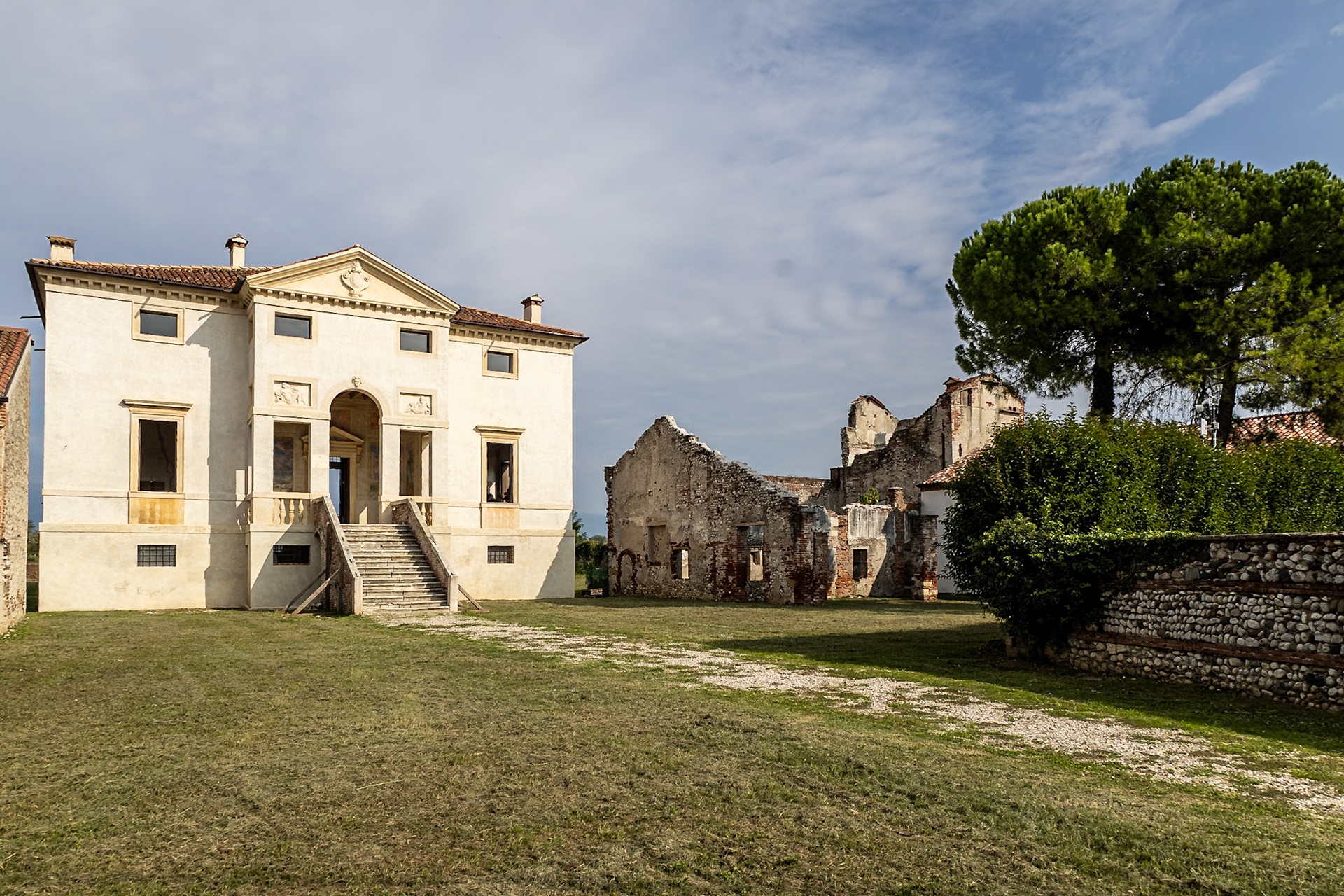 The doorway with a triangular pediment (left) provides access to the central room on the piano nobile, the main floor. In the loggia in front of the entrance, Rita Francesca Grandi explains the work on the frescoes.