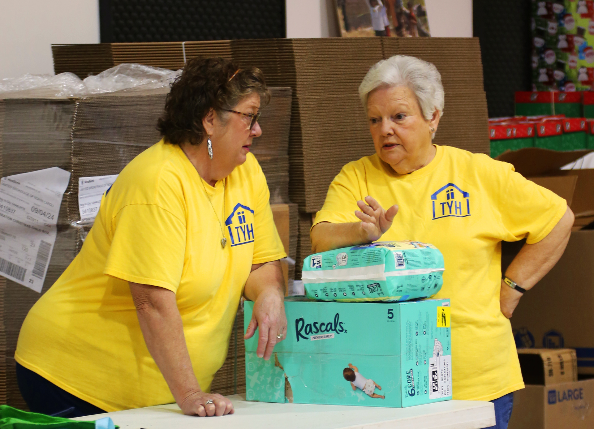"Bless Their Heart" - A photo of two volunteers at The Yellow House discussing the needs of the ministry before the yard sale opens to the public