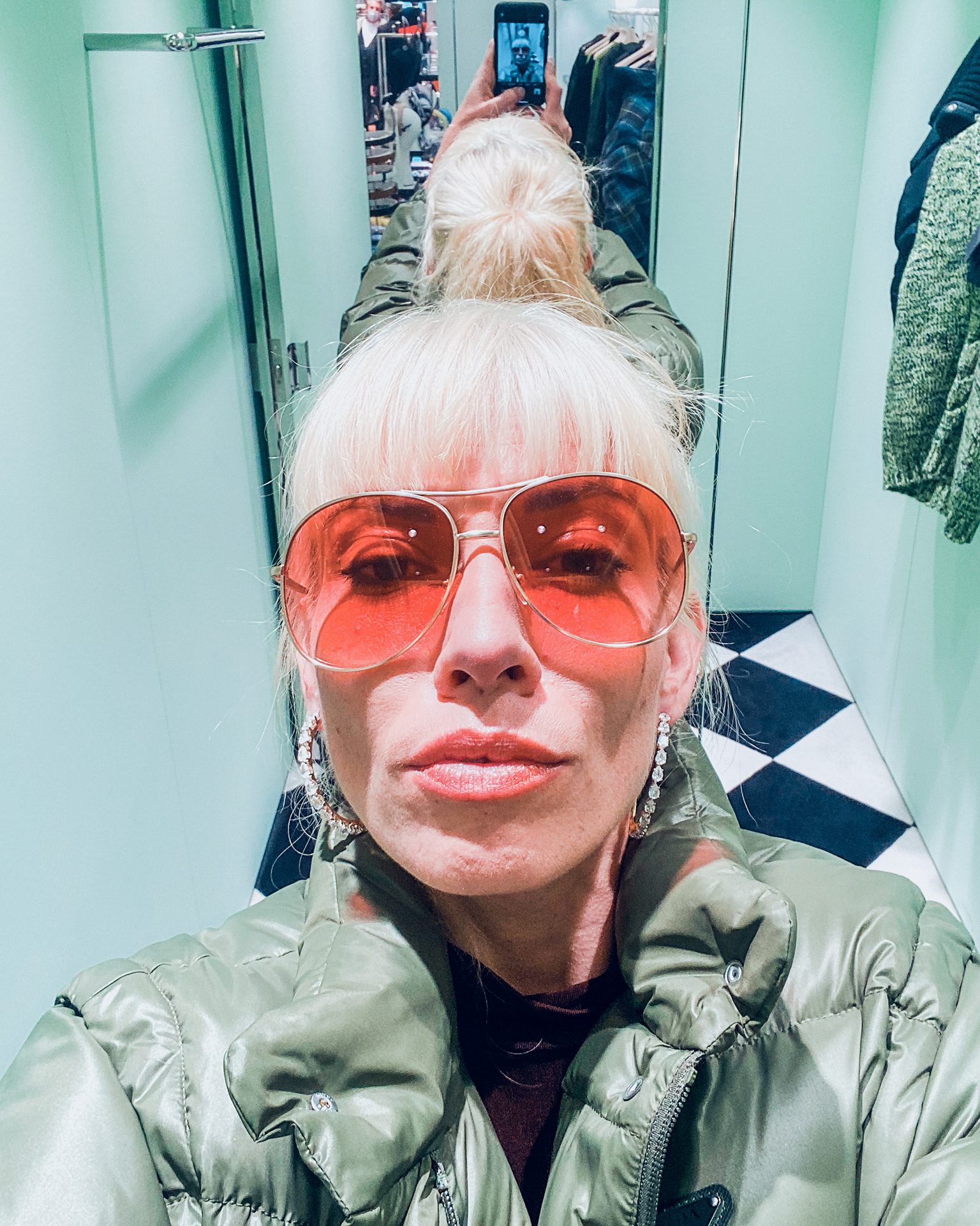 Influenceuse prenant un selfie dans une cabine d'essayage luxueuse