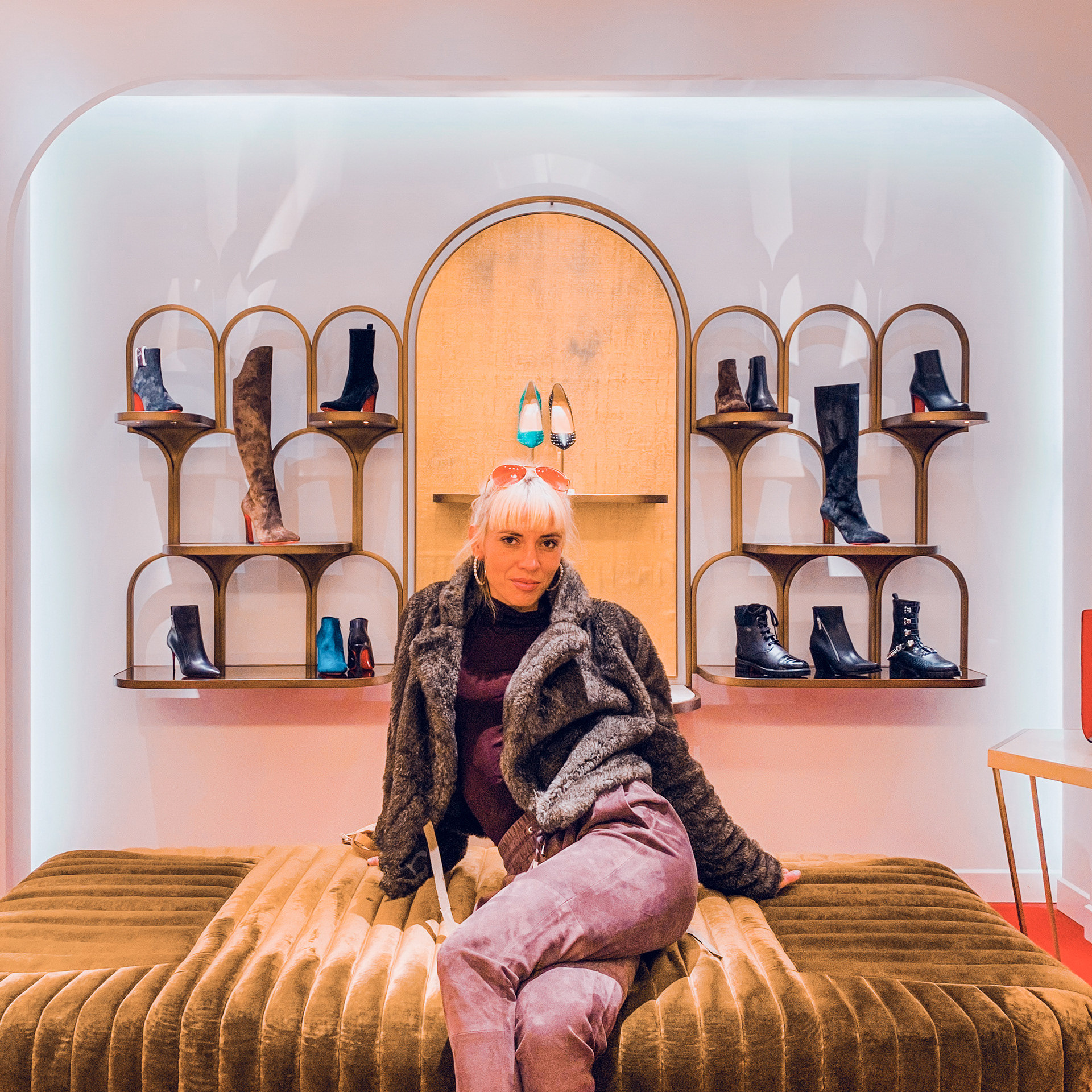 Actrice prenant la pose devant un étalage de chaussures dans un centre commercial huppé