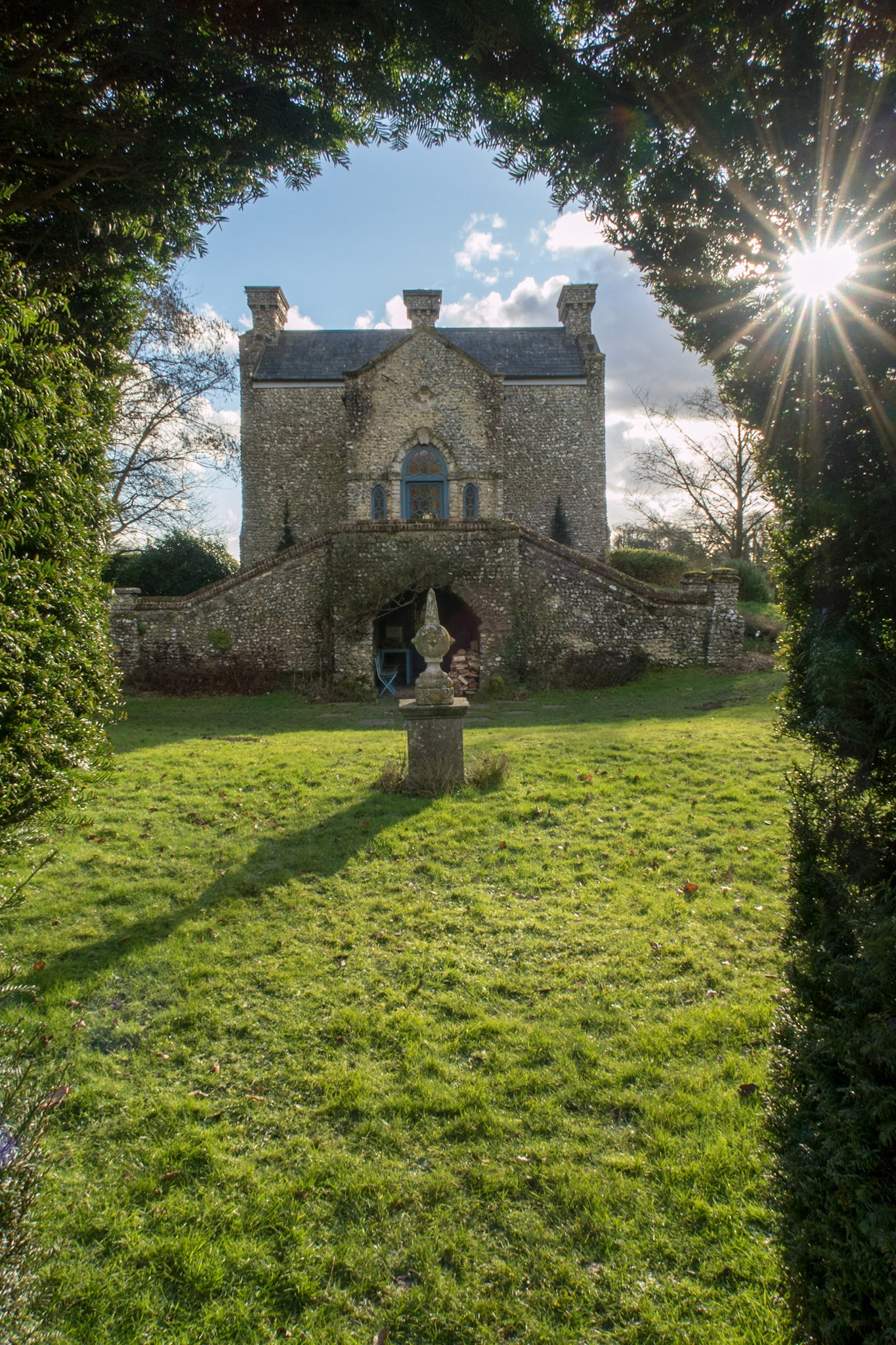 The Dower House through the arch in the hedge