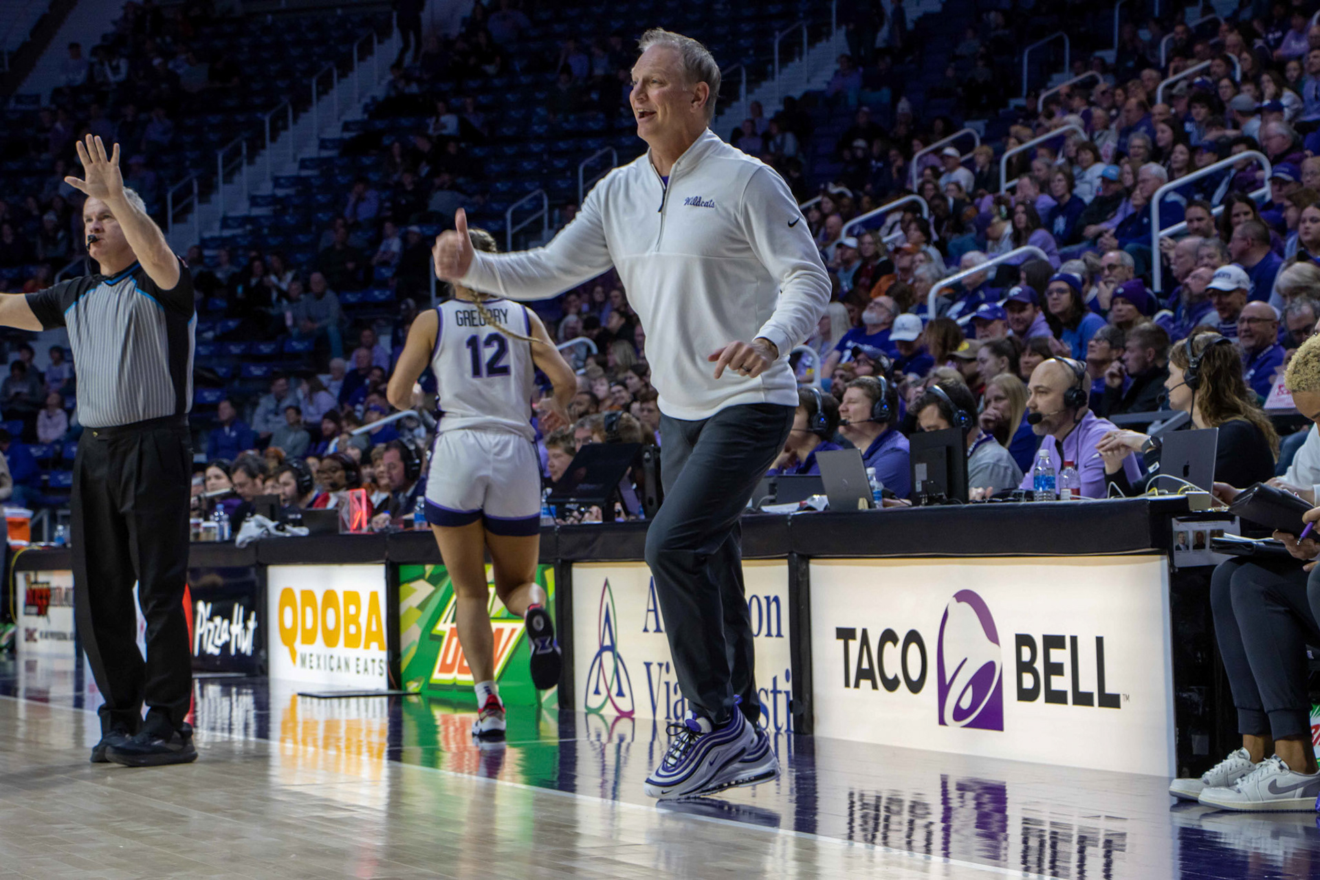 Head coach Jeff Mittie smiles as he directs the offense. His direction pays off as guard Serena Sundell sinks a layup to grow K-State's lead 48-45.