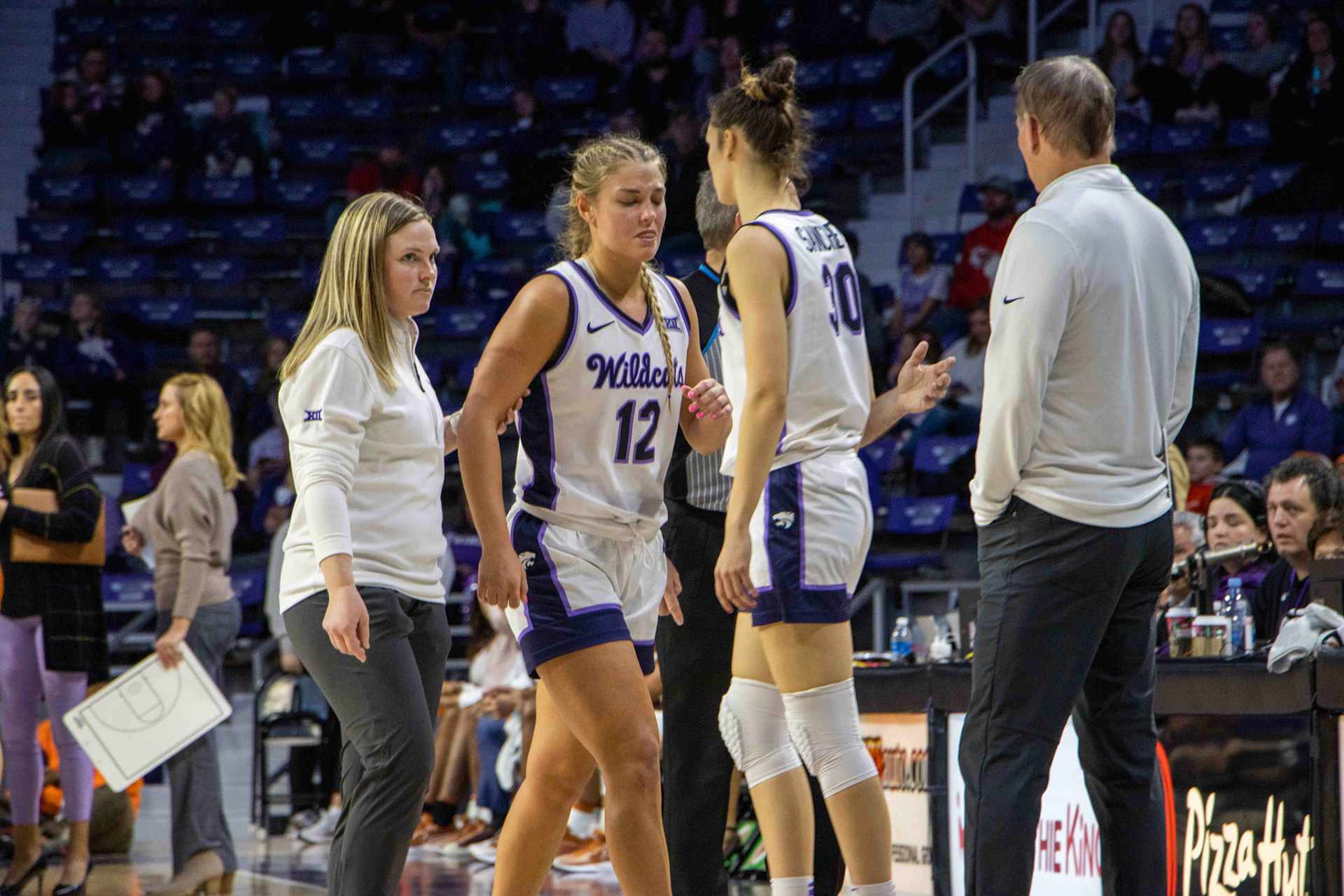 Guard Gabby Gregory switches out with forward Gisela Sanchez as Gregory hobbles back to the bench with head coach Jeff Mittie and assistant athletic trainer Erin Grennwald onlooking. Gregory would not play the rest of the game against Texas as she reaggravated her ankle injury from the third quarter.
