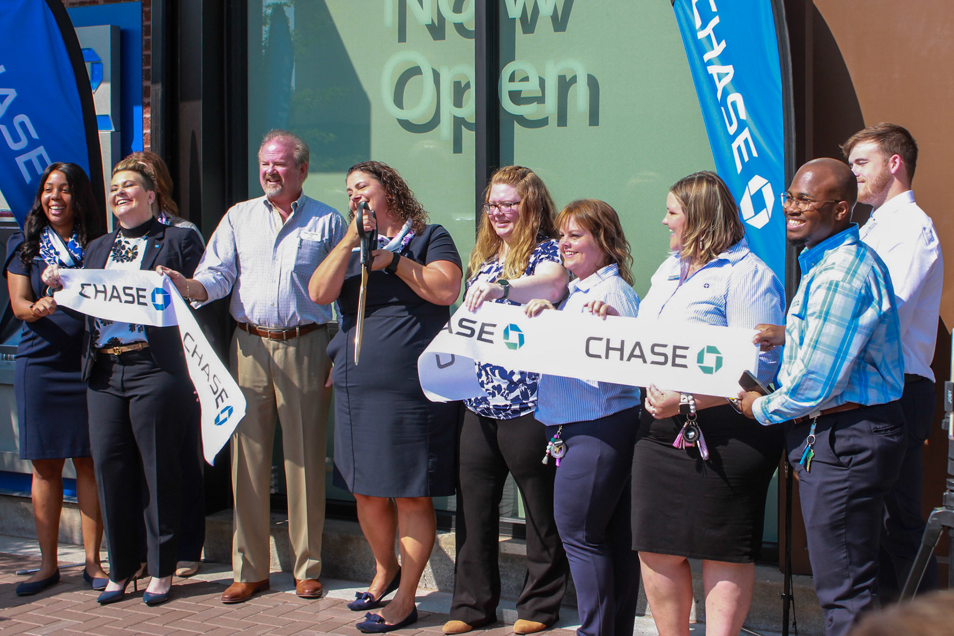 Carrie Rowe, Chase’s Manhattan branch manager, cuts the opening ribbon for Chase's Manhattan branch on Aug. 29.