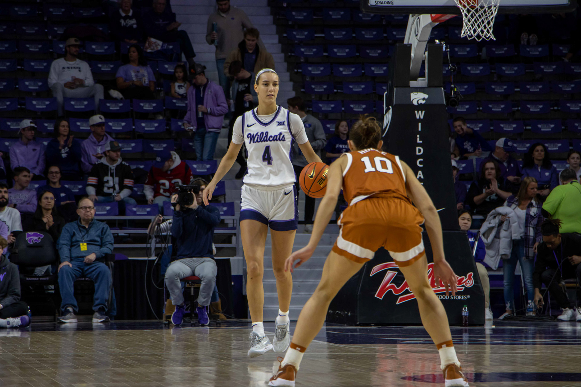 Guard Serena Sundell dribbles down the court, staring down Texas guard Shay Holle. Sundell ended the match scoring second highest on the team with 12.