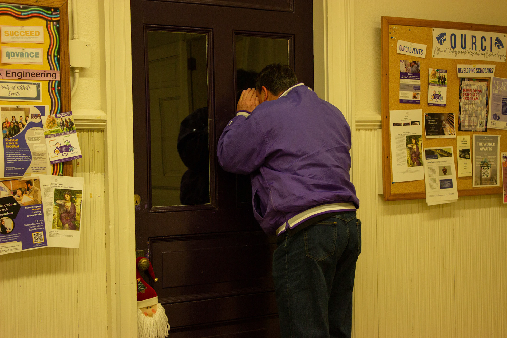Troy peers in a window in Fairchild Hall, thinking it's the room he worked in during his time at K-State.