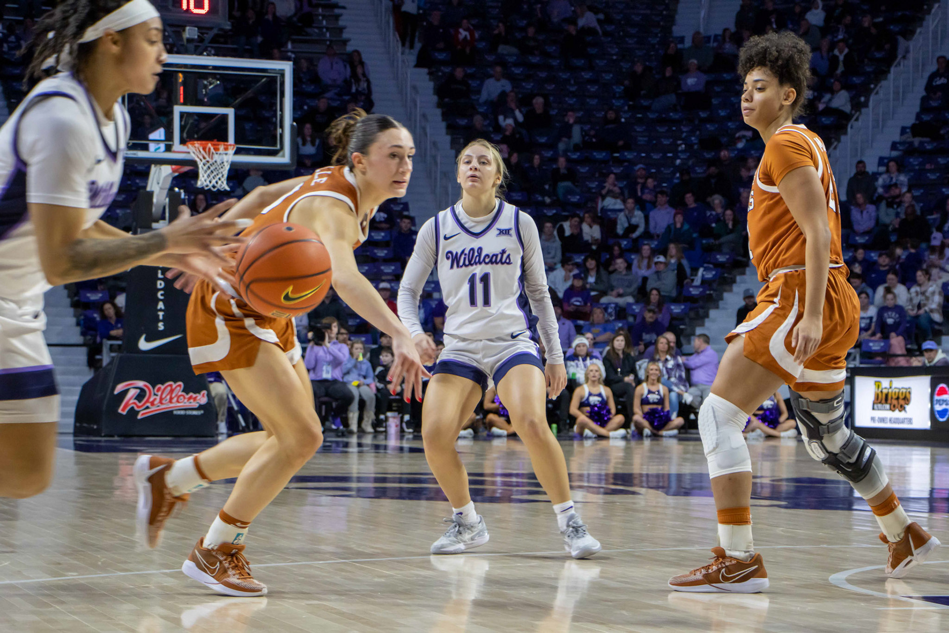 Guard Taryn Sides slips a bounce pass through two Texas defenders to guard Zyanna Walker. Walker immediately drove to the bucket and made the layup, closing the gap 25-23 against Texas halfway through the second quarter.