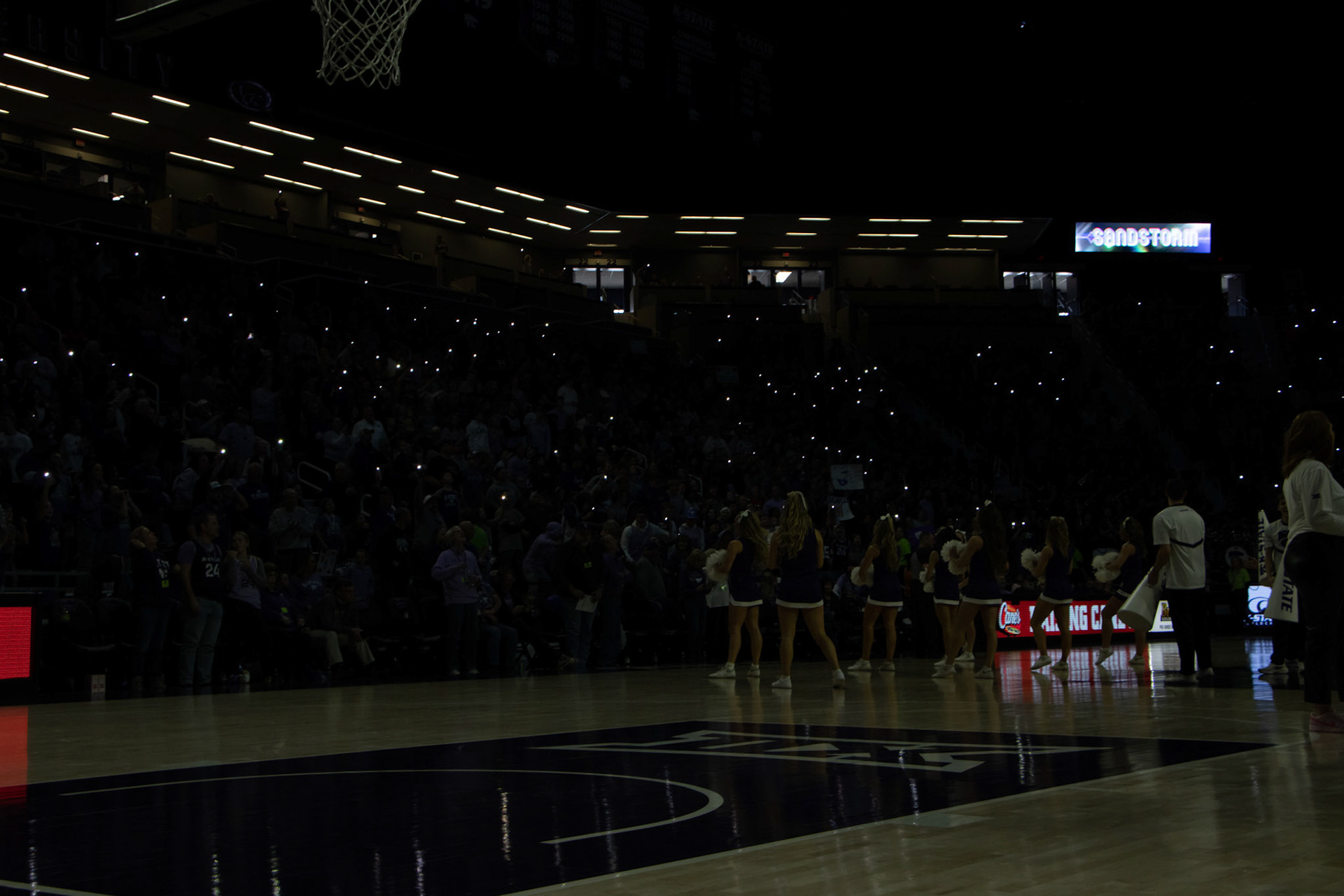 Phone flashlights illuminate Bramlage Coliseum as Darude's Sandstorm starts to fill the arena. Sandstorm is one of many K-State traditions — especially to Bramlage and the basketball teams.