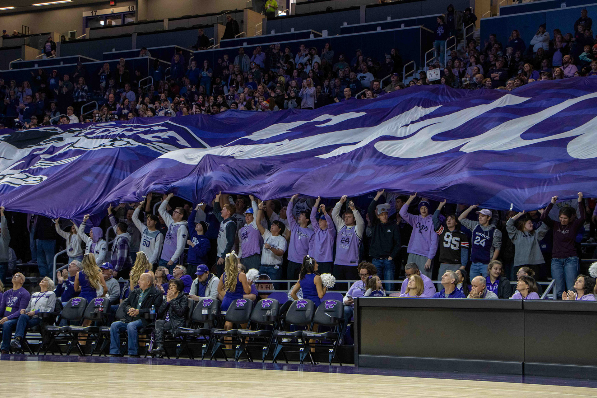 The K-State student section holds up a giant EMAW flag before tipoff against Texas. The game had 7,000 in attendance and also marked the two millionth person to watch the K-State women's basketball team at Bramlage Coliseum.