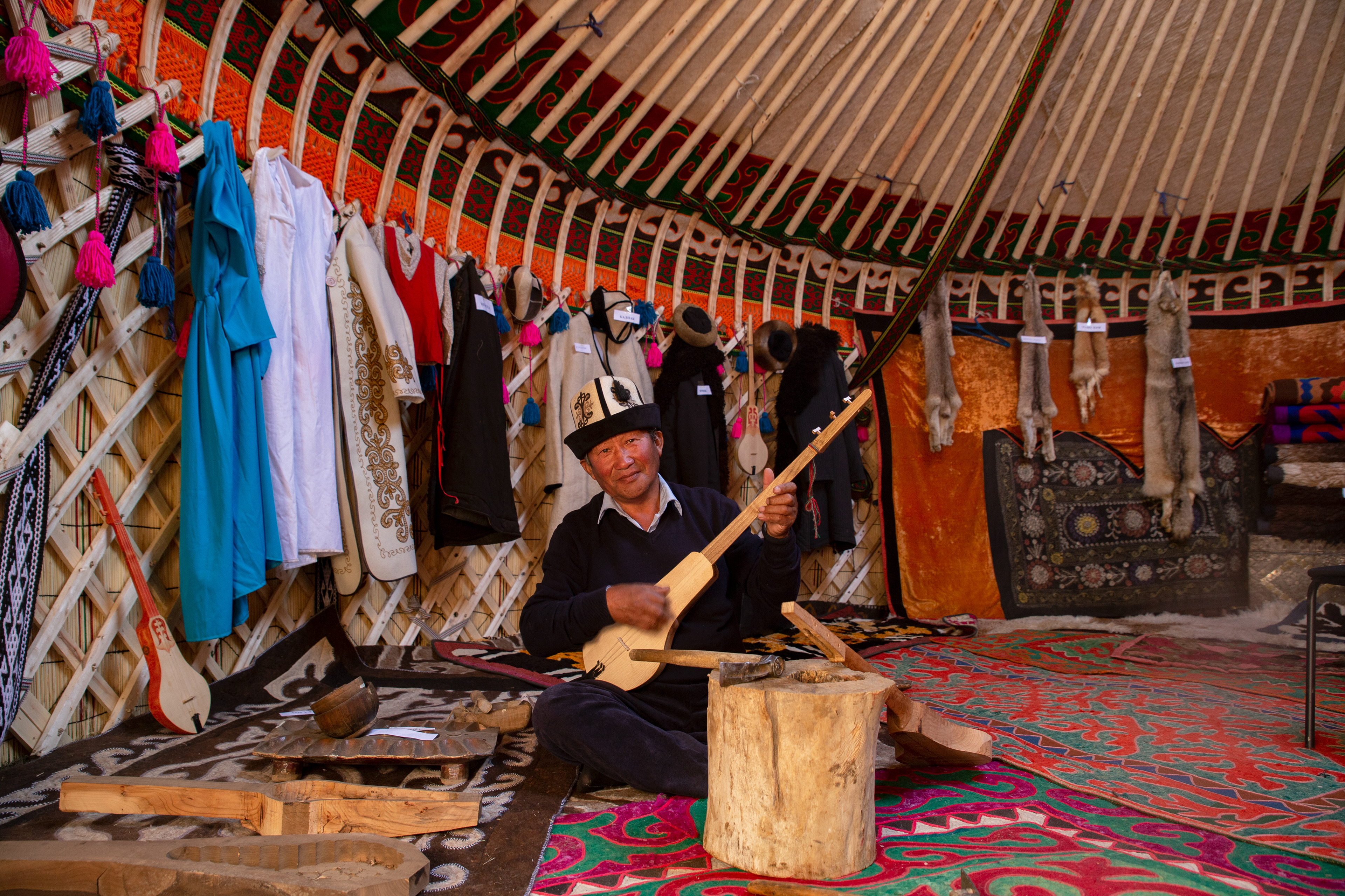 An old man showing his own made guitar