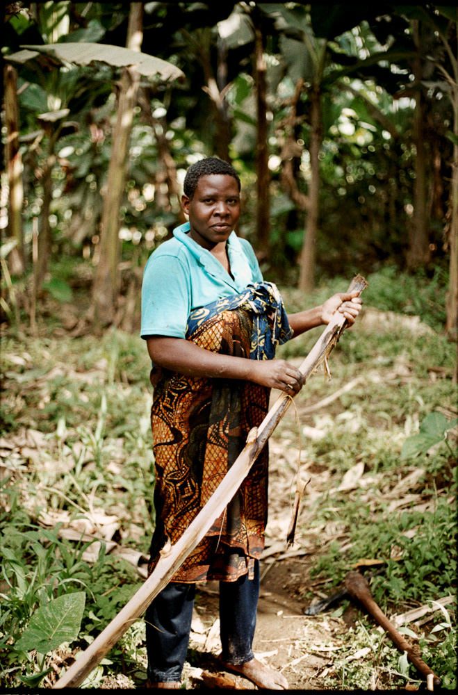 A local woman strips the bark from a felled tree from the plunge pool of the local waterfall.