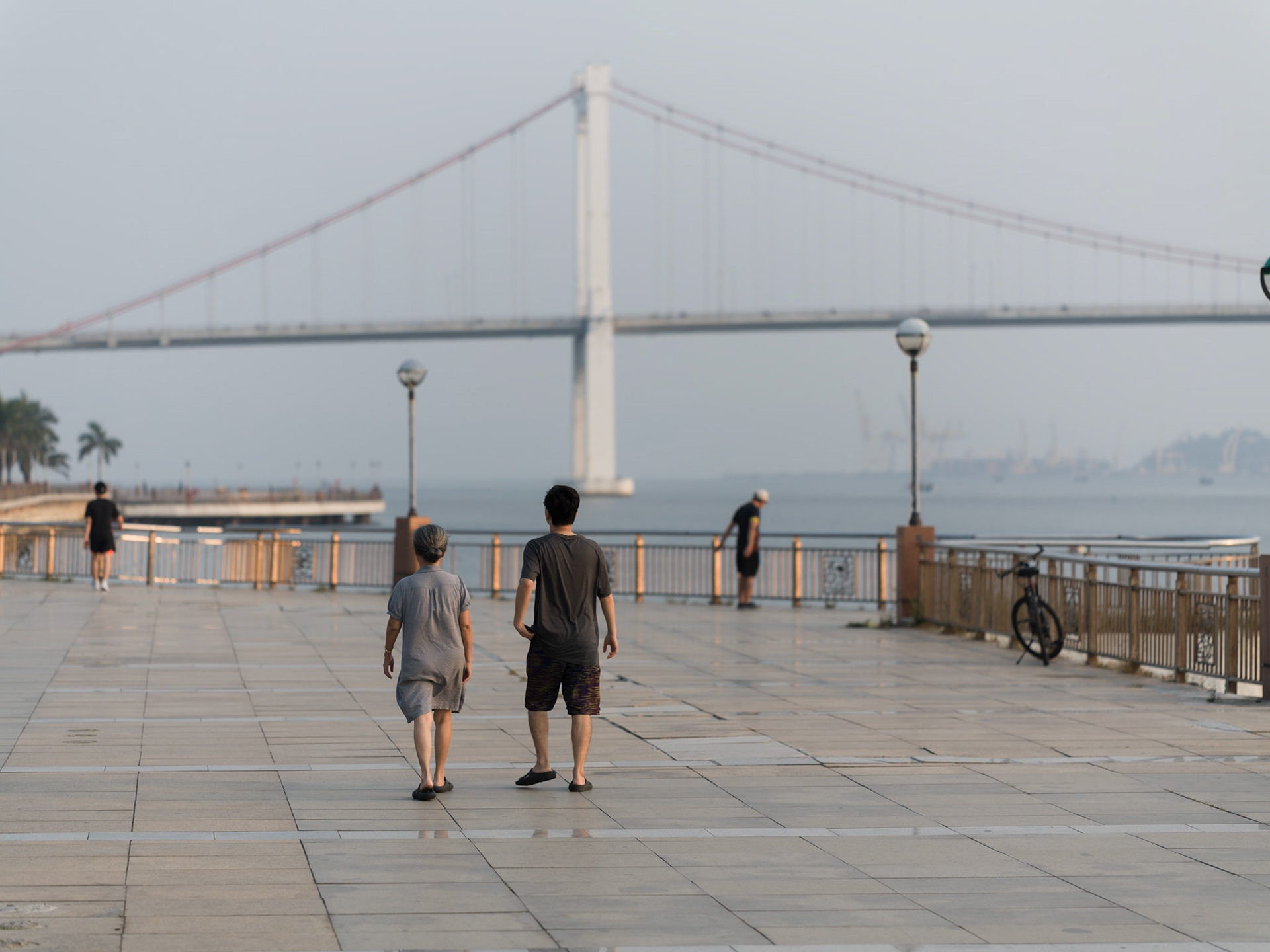 People on their morning walk along the promenade by Thuận Phước Bridge in Đà Nẵng.
