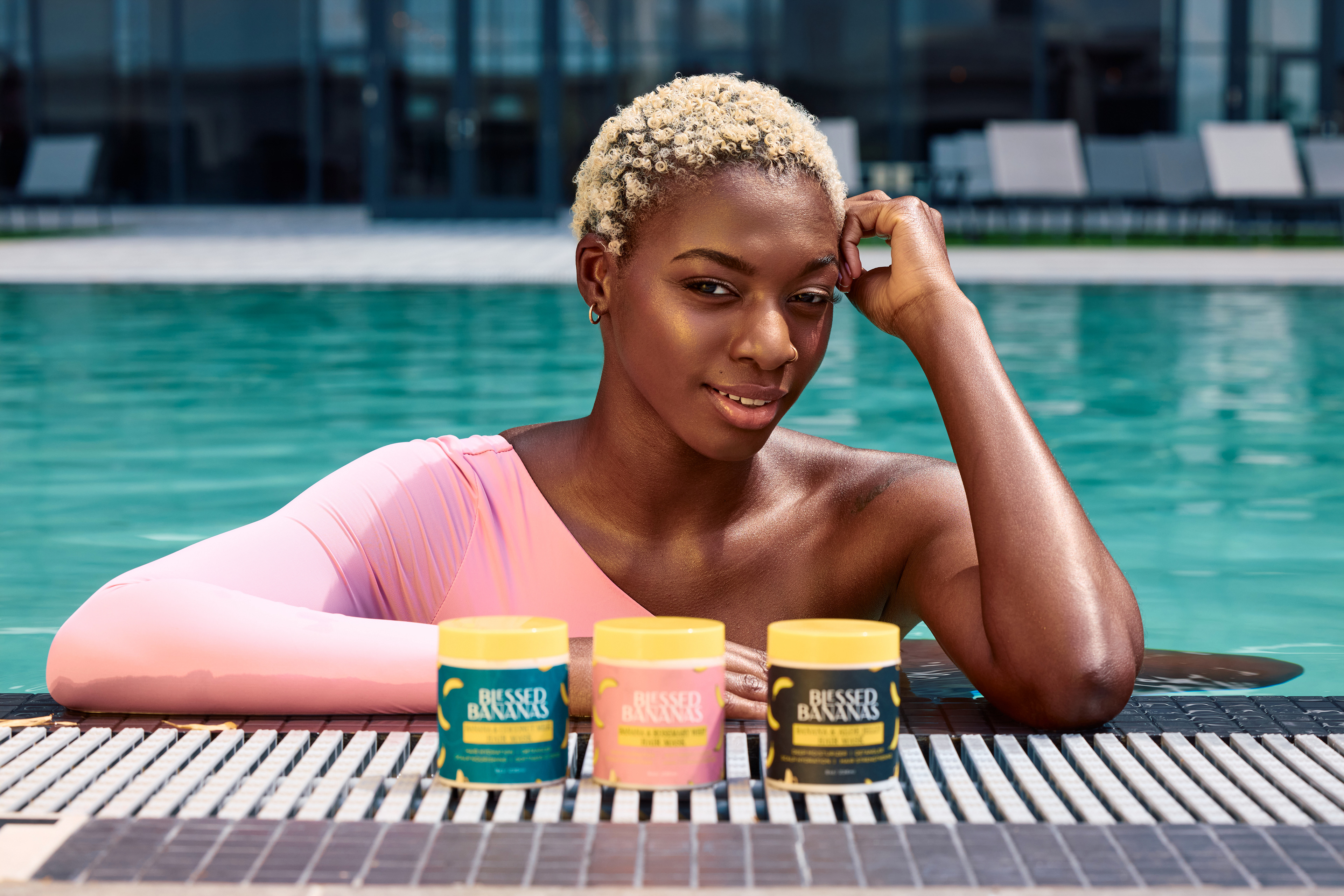 Commercial beauty lifestyle photography featuring Blessed Bananas haircare products by the pool.