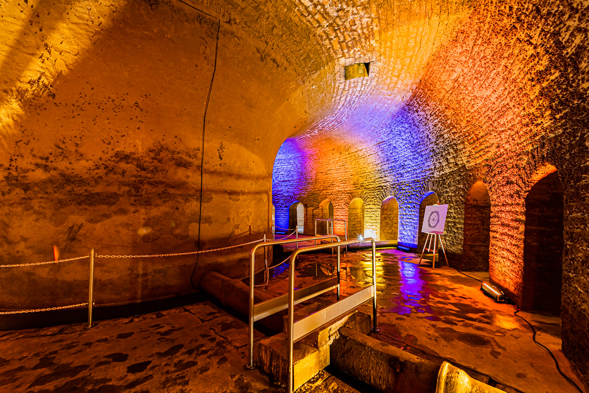 Visite de la salle voutée du réservoir Darcy, vidé une fois par an pour sa maintenance et les visites. Murs en pierres. Mise en lumière.