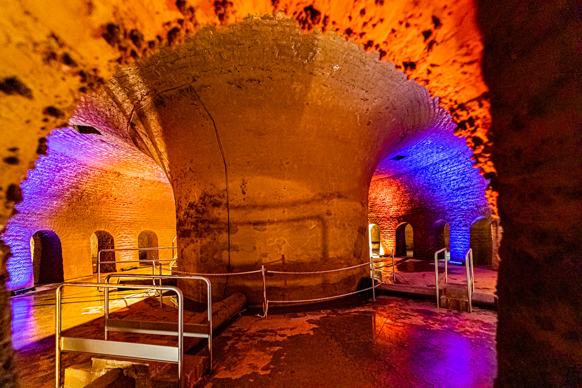 Visite de la salle voutée du réservoir Darcy, vidé une fois par an pour sa maintenance et les visites. Murs en pierres. Mise en lumière.