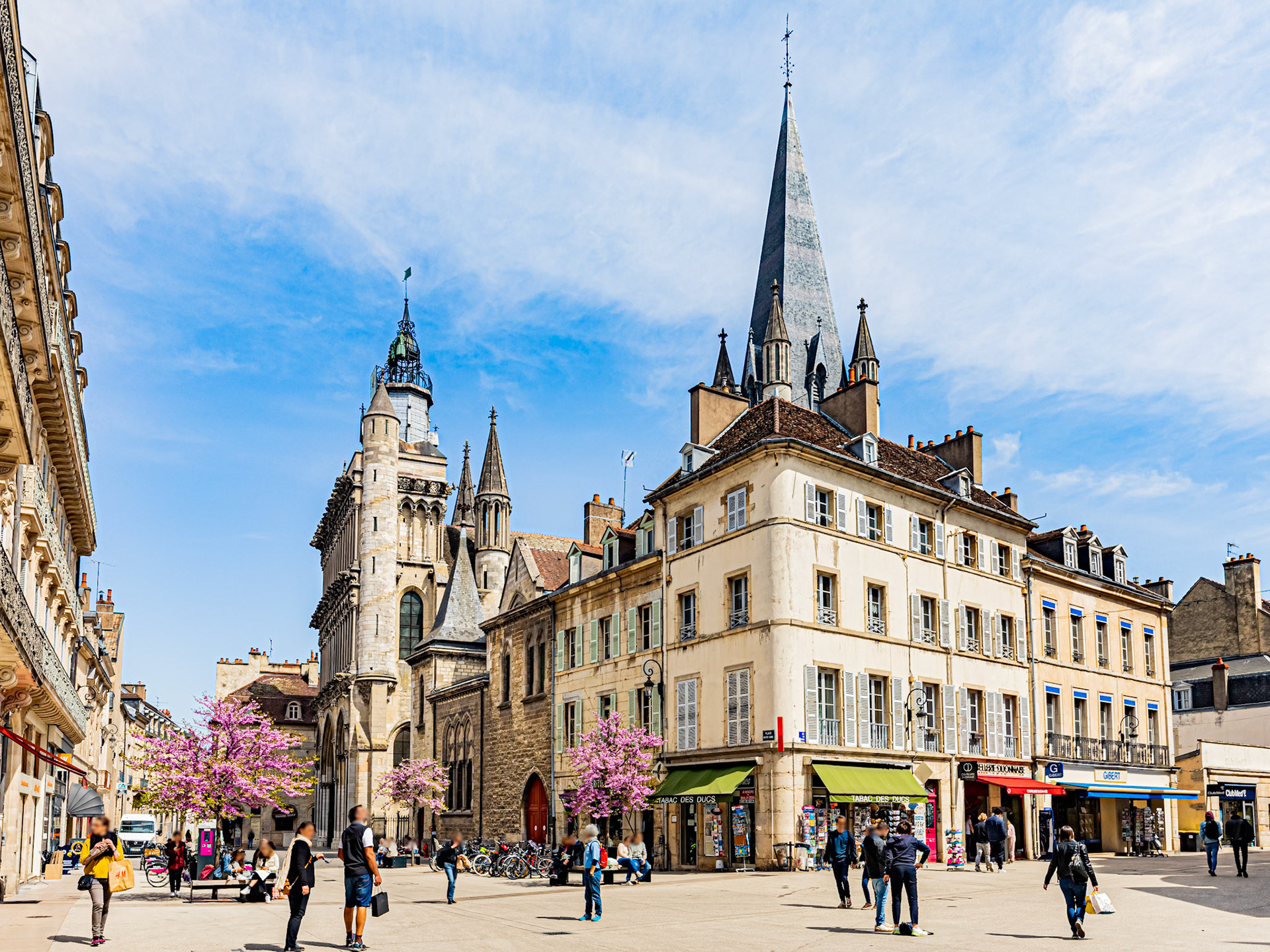 Le printemps place Notre Dame à Dijon avec les passants qui profitent du beau temps.