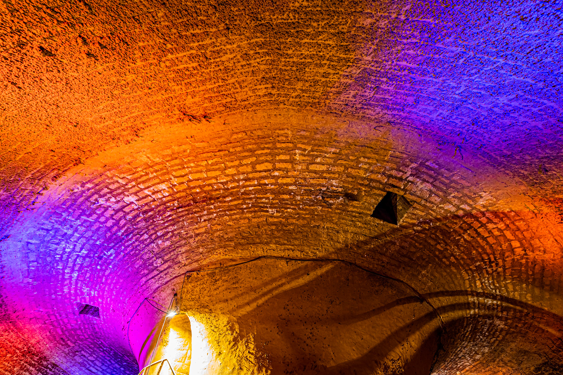 Visite de la salle voutée du réservoir Darcy, vidé une fois par an pour sa maintenance et les visites. Murs en pierres. Mise en lumière.