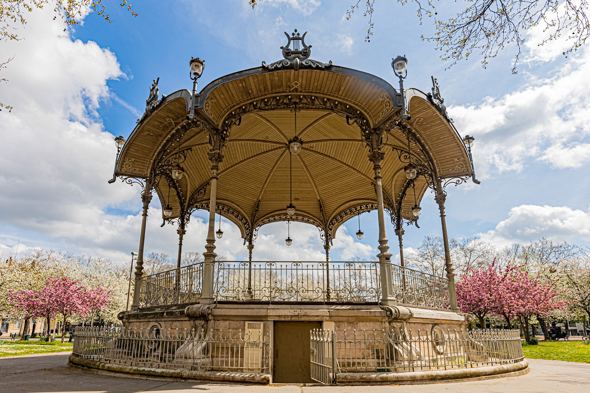 La place Wilson à Dijon aux couleurs du printemps et ses cerisiers japonais en fleur. La fontaine, le Kiosque, les bancs publics.