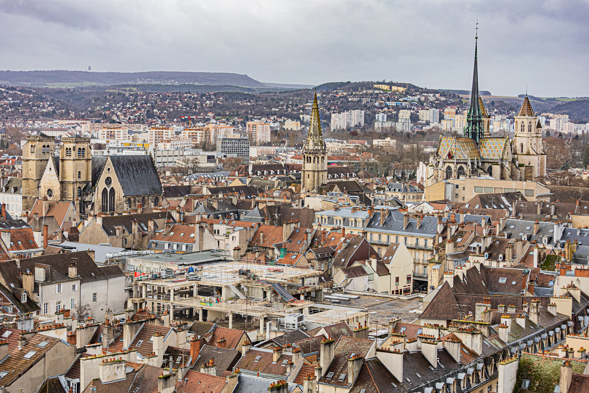 Vue aérienne sur Dijon depuis la tour Philippe Le Bon, gros plan sur la cathédrale Saint-Bénigne, le parvis-Saint-Jean, l'église Saint-Philibert et le centre Dauphine en reconstruction.