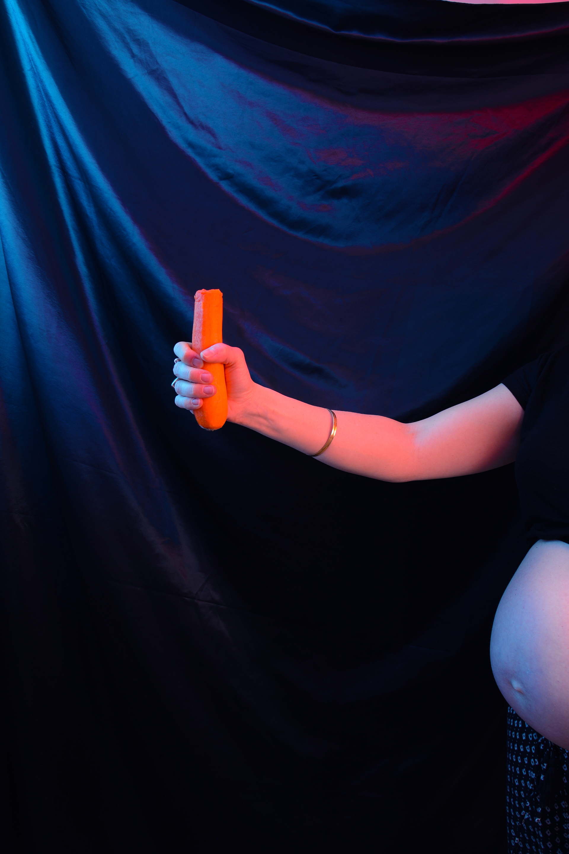 ‘’#2 Eat a carrot and if it gives you hiccups then you are expecting a girl.’’, Georgie White, Photograph, C-Type Fuji Matt print, edition of 10, 2020 ‘’This series is a tongue in cheek look at Old Wives’ Tales and when I became pregnant the second time I decided I wanted to play with the idea of myths. Often regarded as irrational, illogical and absurd stories that over the passing of time have become more of a fanciful saying than anything of truth. The Oxford dictionary understands the term Old Wives’ Tale as ‘an old idea or belief that people now know is not correct’, but are we too quick to write off the term as foolish stories told by senile women? Interestingly, and perhaps unsurprisingly, what I discovered with the traditional Old Wives’ Tales was the ingrained prejudice against women. The outlook of the myths hint at the desire to bear a cherished baby boy and not another ghastly girl. The traits to carry a boy are kinder to the mother's figure and fatigue, whereas there is abrasive contempt in birthing a little girl who will give you a hideous shaped bump, cover you with spots, greasy hair or baldness and even riddle you with indigestion. Playing with the theme I created my own pregnancy Old Wives’ Tales which emphasise the inequality in the result.’’