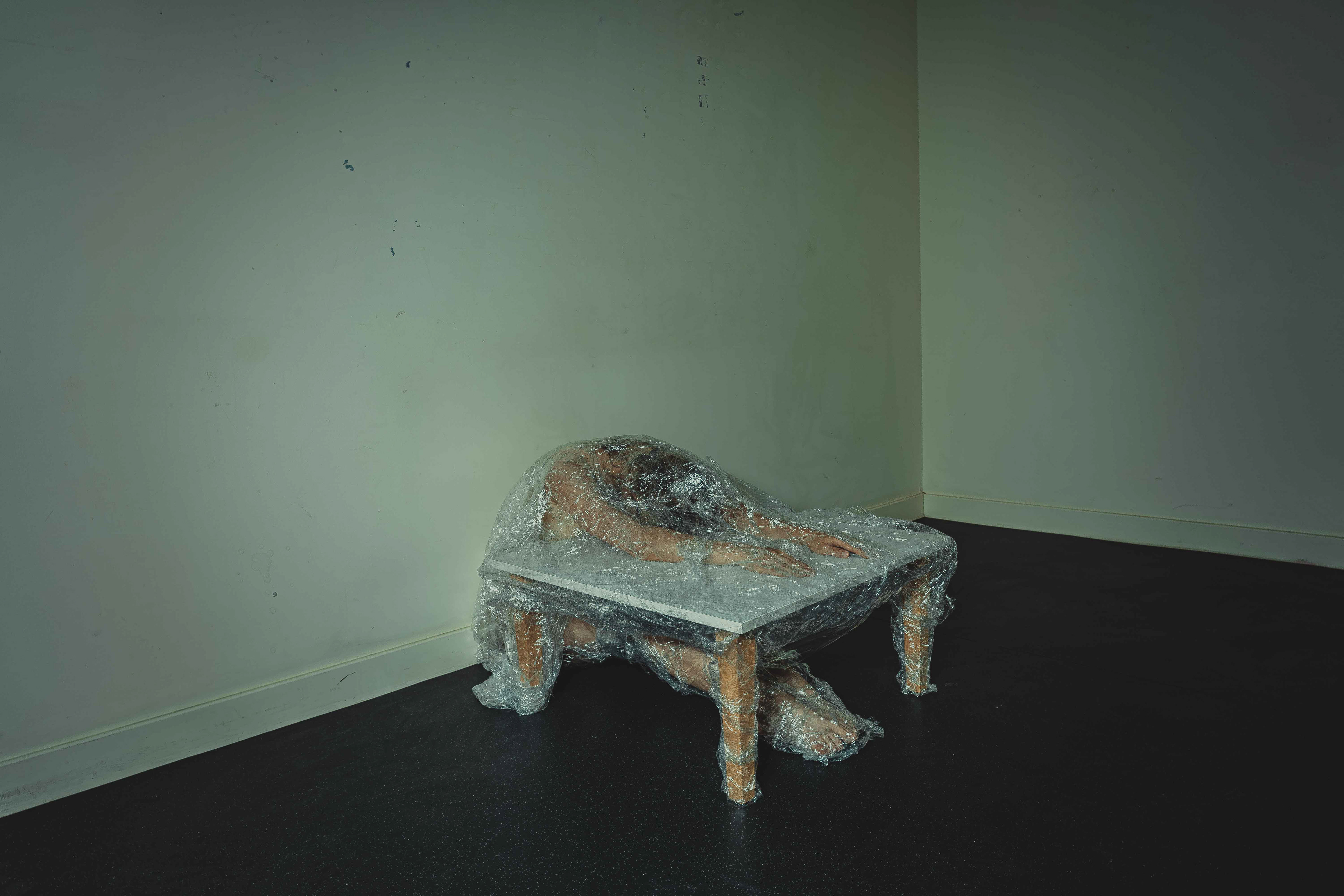 “Blob”, Digital Photograph, 33.87 x 50.8 Eva Wang The inability to distinguish between my body and other and accept the loss of my dependence makes me unable to become a subject/self. I’m only a belonging. My body is an object in this situation where it’s got no control over. And other/object manipulates the body. I thought about objects that were supposed to support the body and shape the body at the same time. When the differentiation cannot be realised, the body keeps the manipulated shape. Cling film tells the clingy characteristic of the self in a “relationship” which eventually causes too much pressure to other and drives other away. It shows the desire of not letting go of the support, the rejection of separation, and the result of disabling the function of the body. There’s a conflict between the natural desire and the knowledge of its futility. The nature wins over in this situation in some degrees. But the result still shows the state of being stuck. It also shows the body cannot become a subject/self this way.