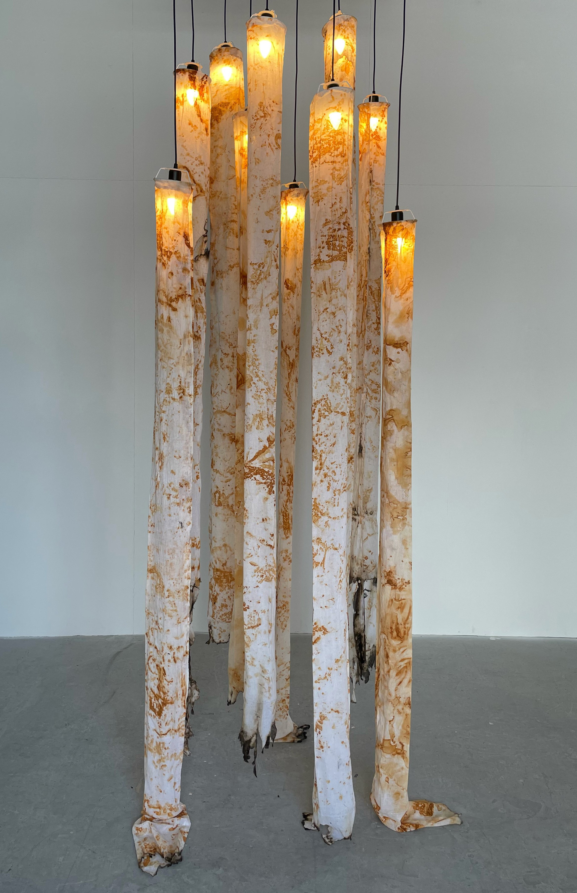 “Ghosts”, Fabric, sculpture, installation, 1x3x1 metre Blauhaus Blauhaus.co.uk @blauhaus__ A qx3x1 metre tall light installation made from handmade muslin cloth lampshades. The fabric was dyed with rust by wrapping found rusted metal pieces into wet fabric. Each pattern is an imprint of a piece that once had a meaning, that was once in someone's life. I encourage the viewer to see rust as a hallmark of a lived life and not as a symbol of decay. The lamps with the imprints are hanging like ghosts above and around us.