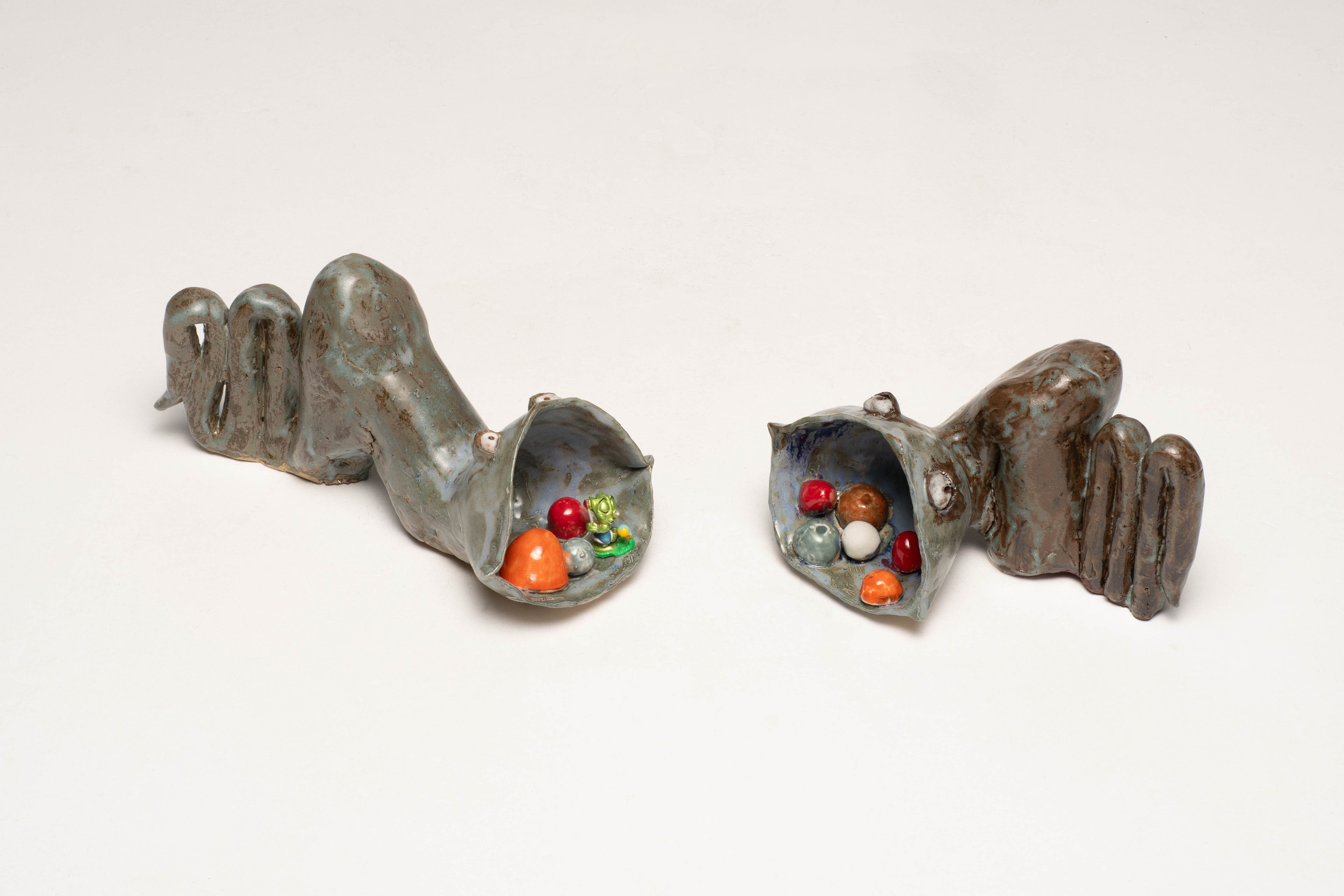“Shed Salty Tears” Helen Birnbaum, Ceramic and reclaimed media, 2023 “In 2023, 480,343 pieces of litter were found on UK beaches, by 2024 this had become 764,451.. The fish, marine animals and birds that become caught in plastic rubbish suffocate, stave and drown: hundreds of marine species have been harmed by the debris we leave in our oceans. As our planet faces greater and greater environmental problems I strive to create work that combines important ecological messages alongside sustainable practice. Shed Salty Tears draws attention to the bleaching of the sea bed and pollution and consists of many ceramic pieces which are integrated with found objects.  Calling us to take notice of this environmental crisis is the statue of a woman at the centre of the ceramic installation Shed Salty Tears; the voice of the planet, calling us to notice the state of our environment degraded by industrialisation. Crushed cans, rusty metal forms and discarded plastic cluster around the central sculptures. Reclaimed materials challenge viewers to consider what they consume and how it is discarded.  Shed Salty Tears is a triptych with each of the three separate sections having their own particular emphasis. Each section has approximately fifty white, grey and blue shells, corals and other sea life surrounding three large central sculpted figures; a telephone; an African harp and a crying figure shedding salty tears. In striking contrast brightly coloured ceramic made red, orange and green drinks cans, milk bottles and baked bean cans suggest the detritus causing damage to our seas and beaches.  Shed Salty Tears also includes a selection of bizarre sea creatures envisaged as part organic and part metal debris suggesting that because of the rubbish we throw into the sea this is what the creatures might even become - part organic matter and part the rubbish we humans have left behind.” helenbirnbaumceramics.com  @helenbirnbaumceramics