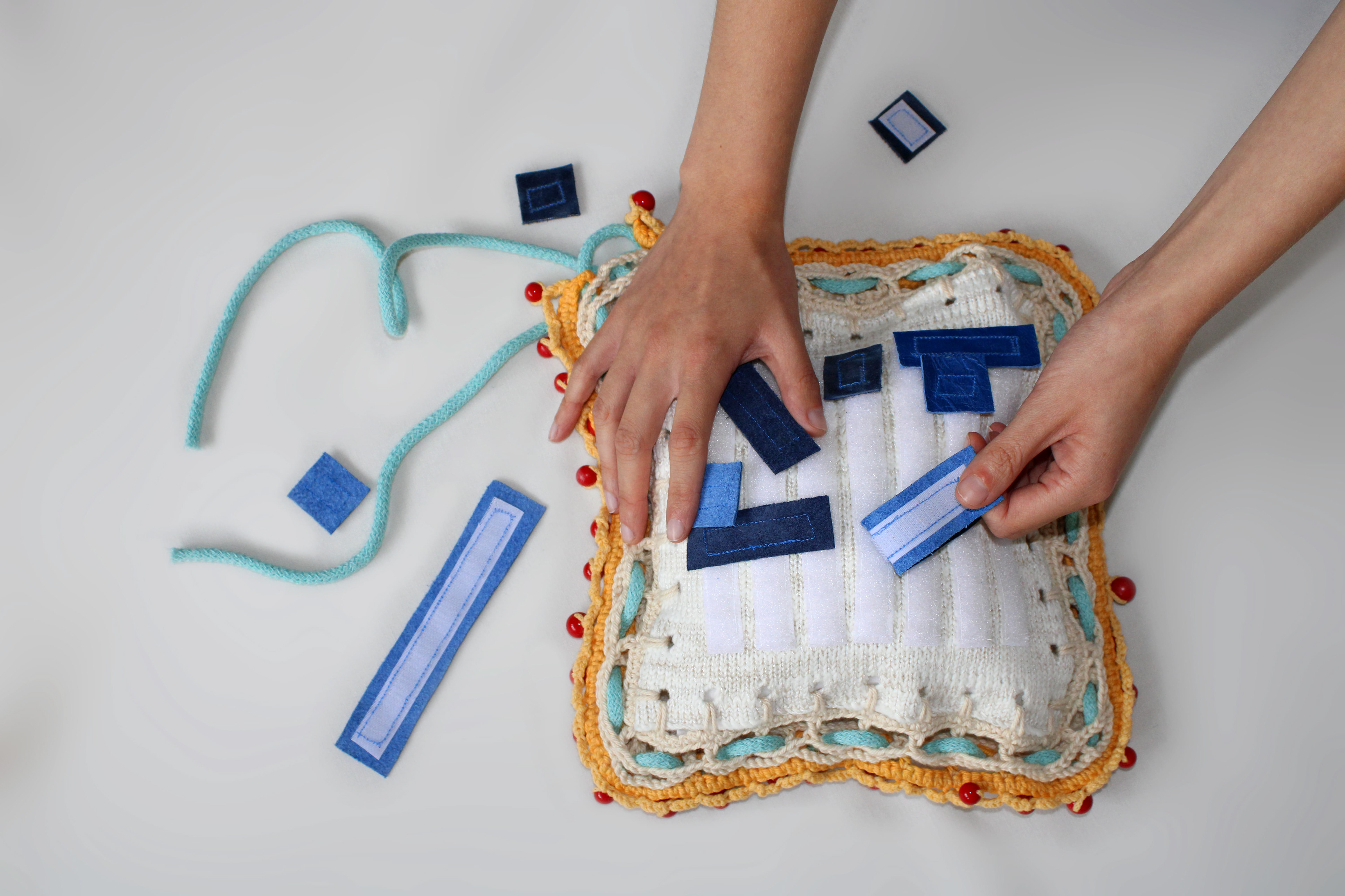 ‘’Material Play’’ Ffion Evans, textiles and craft, 2020 “Material Play is a collection of objects created during 2020 which revolve around tactility, playfulness and wellbeing, focusing on benefiting people suffering from mental health issues through textiles. A mixture of second hand and biodegradable materials are used through knit and traditional craft methods to create the collection of objects. The Stick and Tear Square is one of the items made which combines texture and playful interaction together to create a stress relieving object.” @ffionevanstextiles
