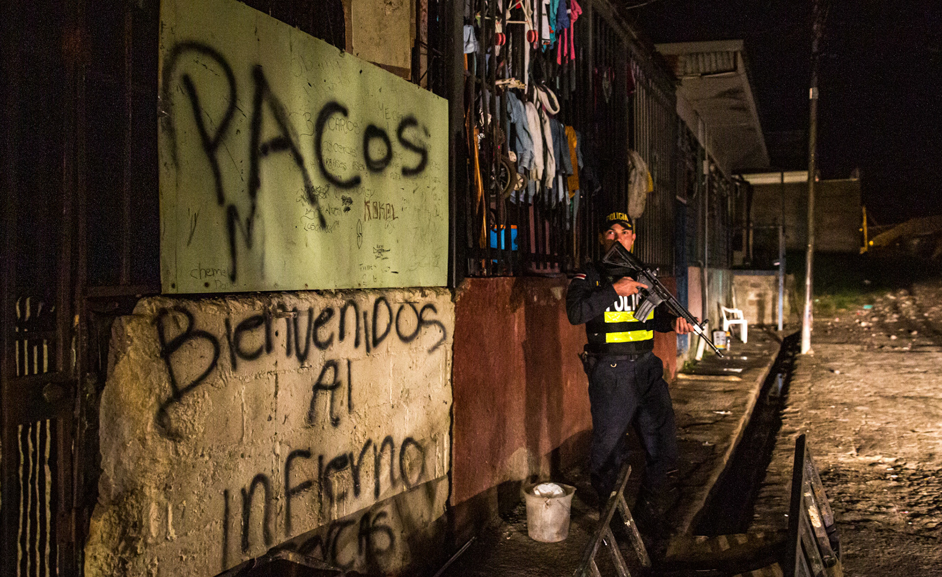 "Cops. Welcome to Hell." A police officer stands guard outside a former drug bunker that belonged to "Pollo", a notorious Costa Rican drug lord.