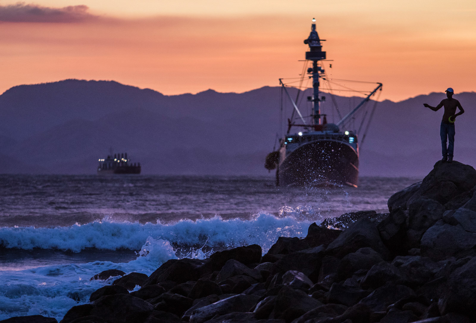 A local fisherman in Puntarenas and a foreign purse-seine vessel in the background.