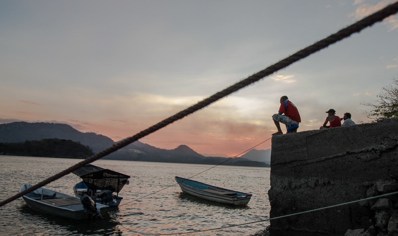 Fishermen in Puerto Nispero sit and watch the sunset.