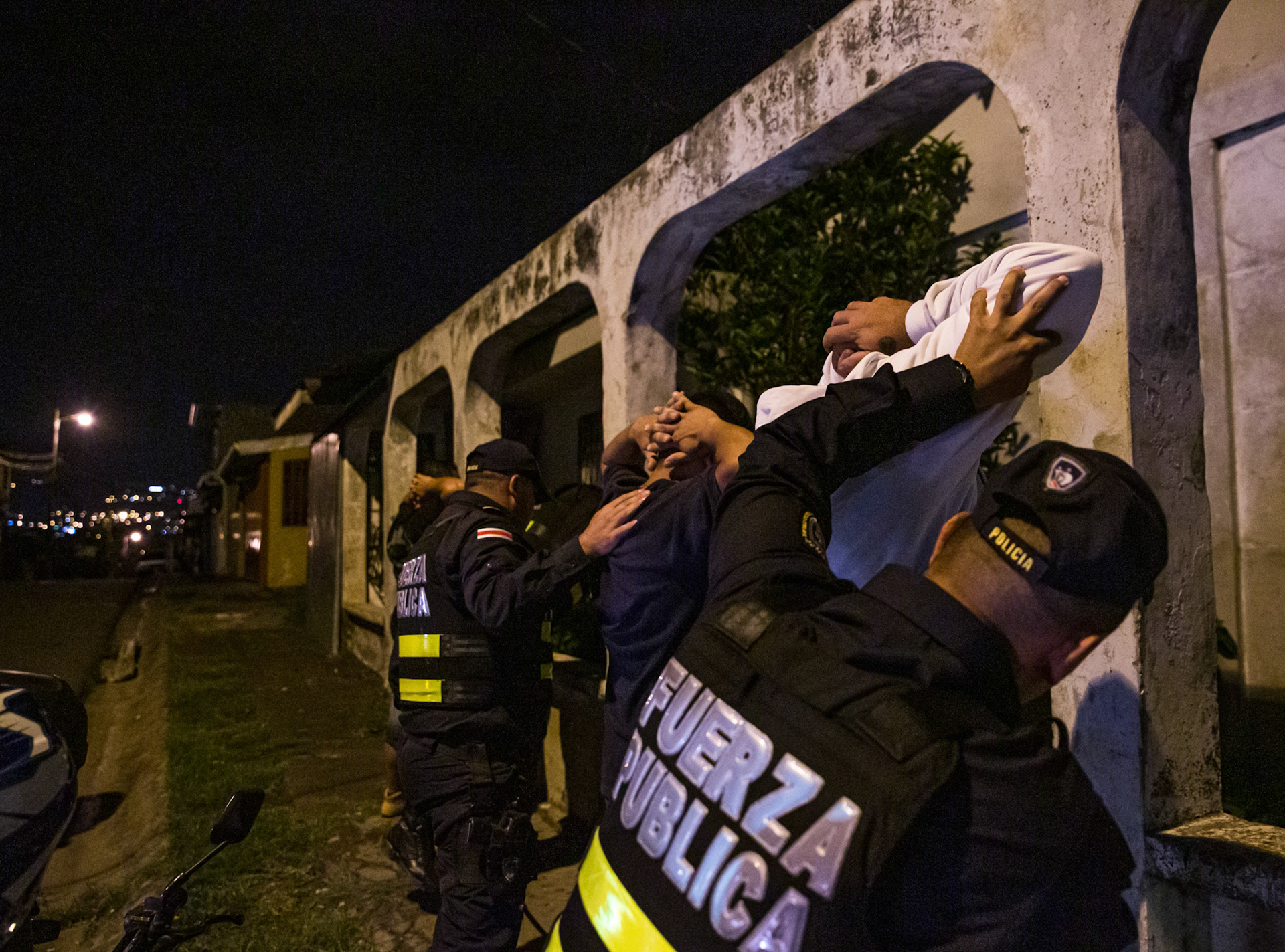 Police searching men for drugs.