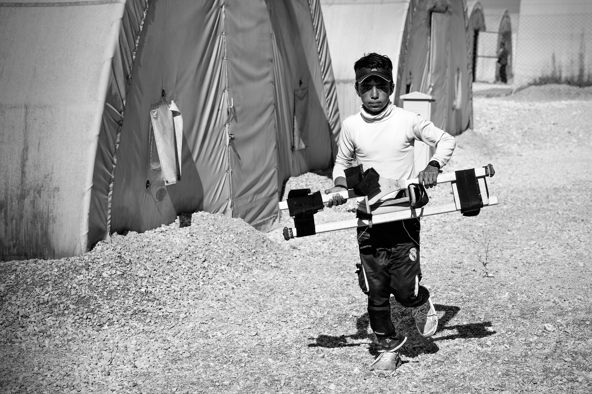 A young refugee boy running with hurry to catch the stilt training. Nusaybin Refugee Camp, Mardin