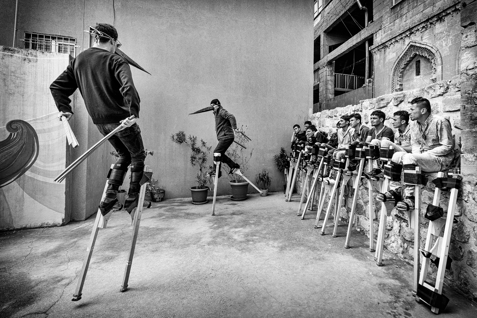 Instructors showing the refugee children the key figures when they have to perform on stilts.