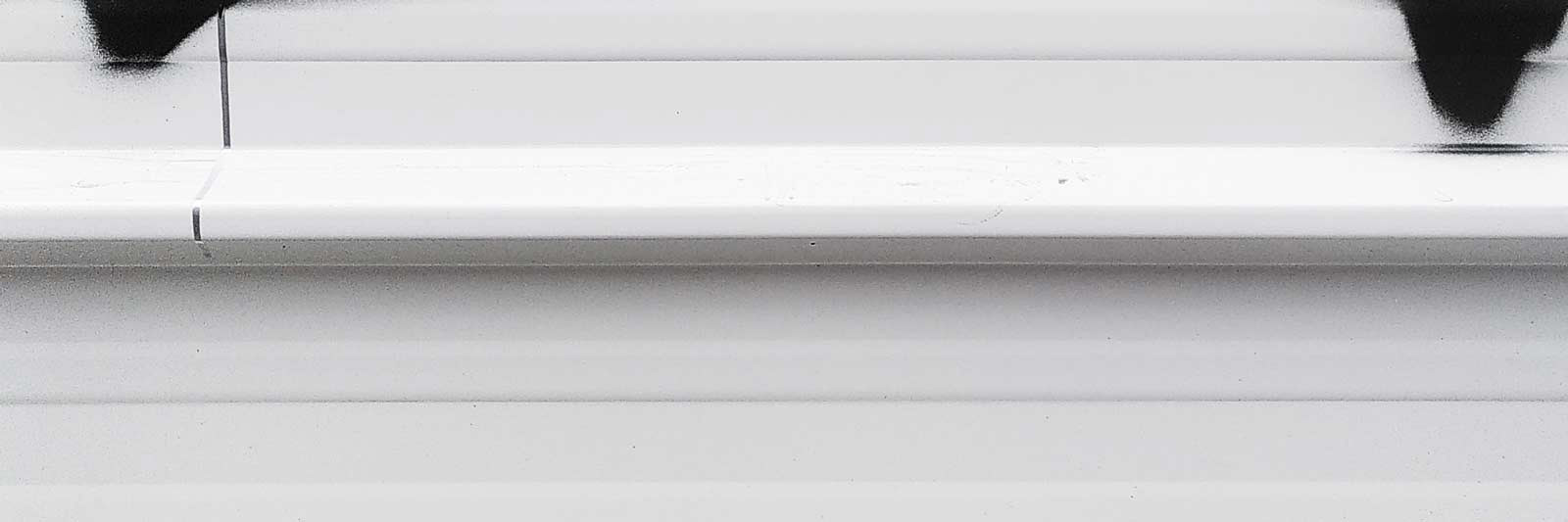 Palissade en métal blanc avec fragments de tag noir