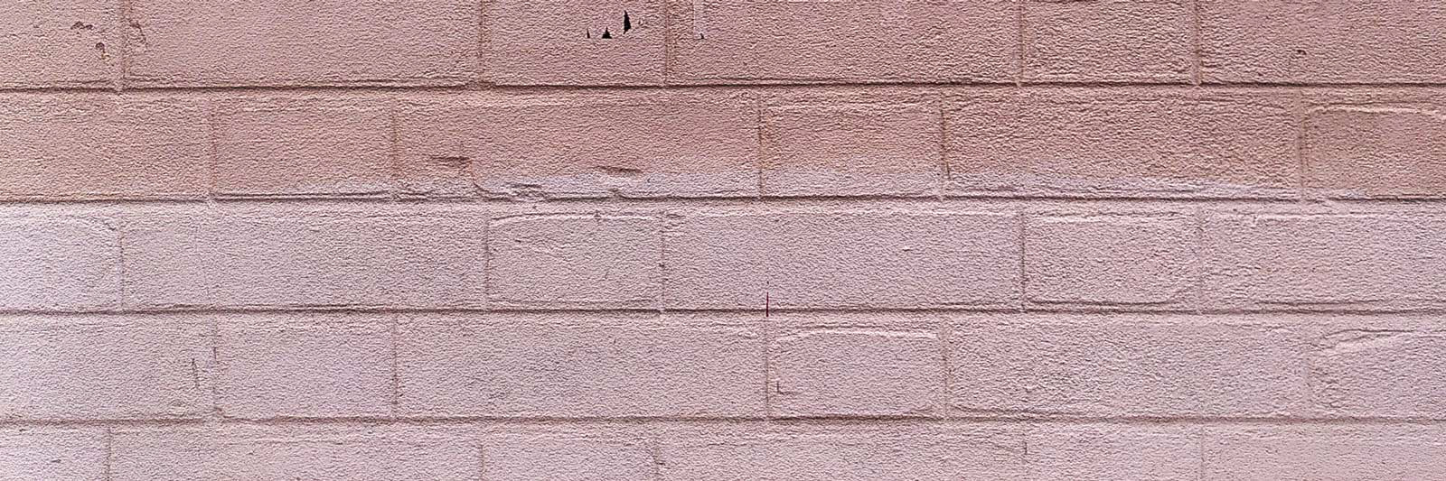 Mur de brique peint en deux teintes de rose