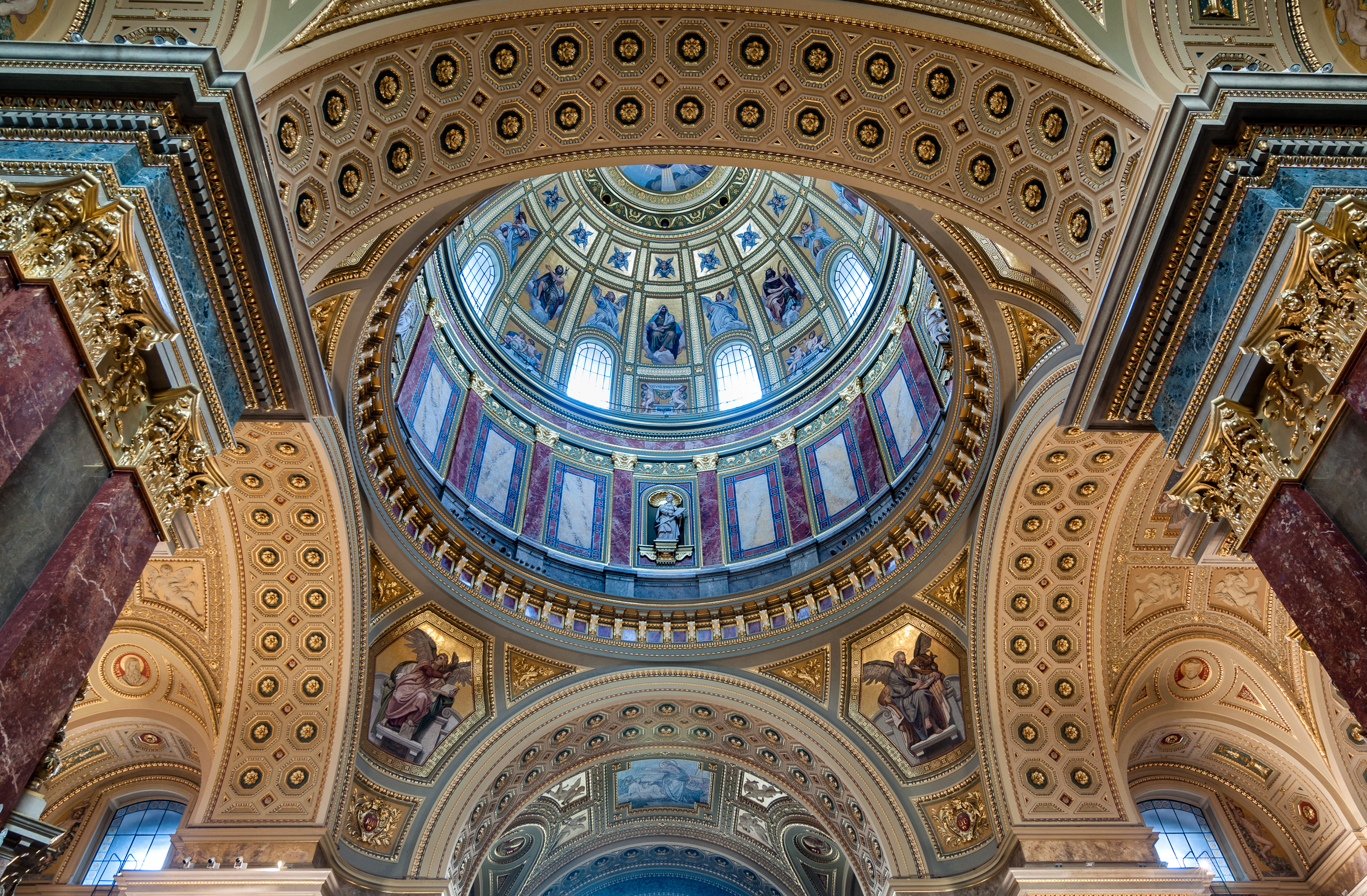 Looking up into the intricate, gold-adorned dome of St. Stephen’s Basilica, a masterpiece of Neoclassical architecture.