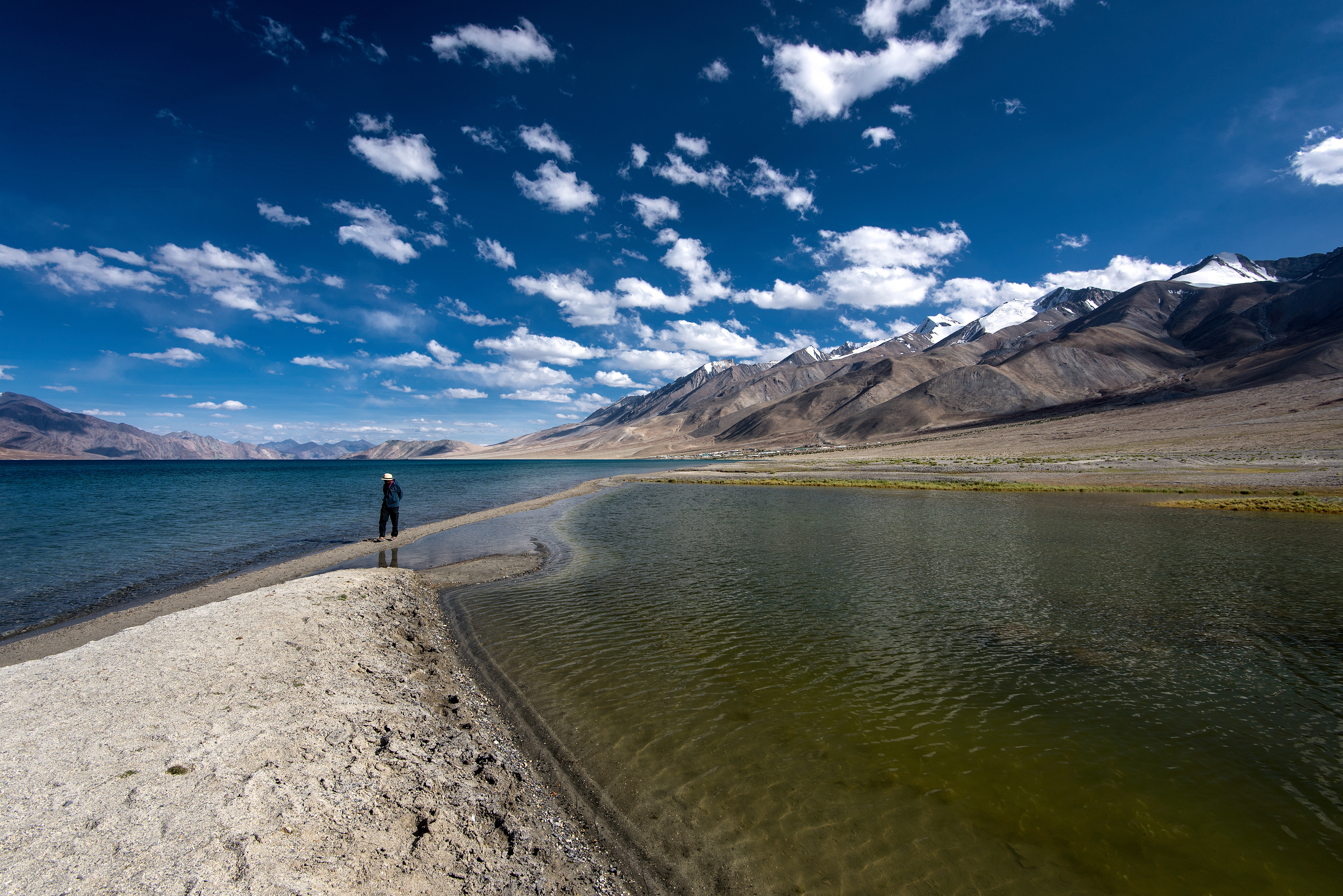 The famous sandbar at Pangong Tso, known popularly as the '3 Idiots Point,' extending into the crystal-clear, color-changing waters of the lake