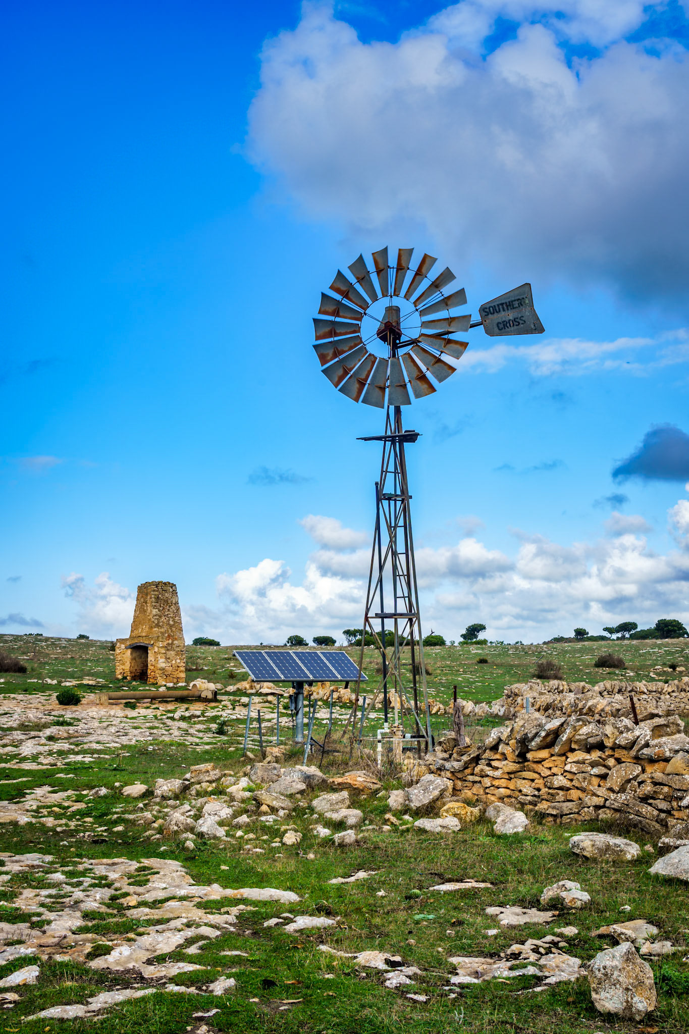 The windmill is now supplemented by solar power to pump water from underground for sheep grazing.