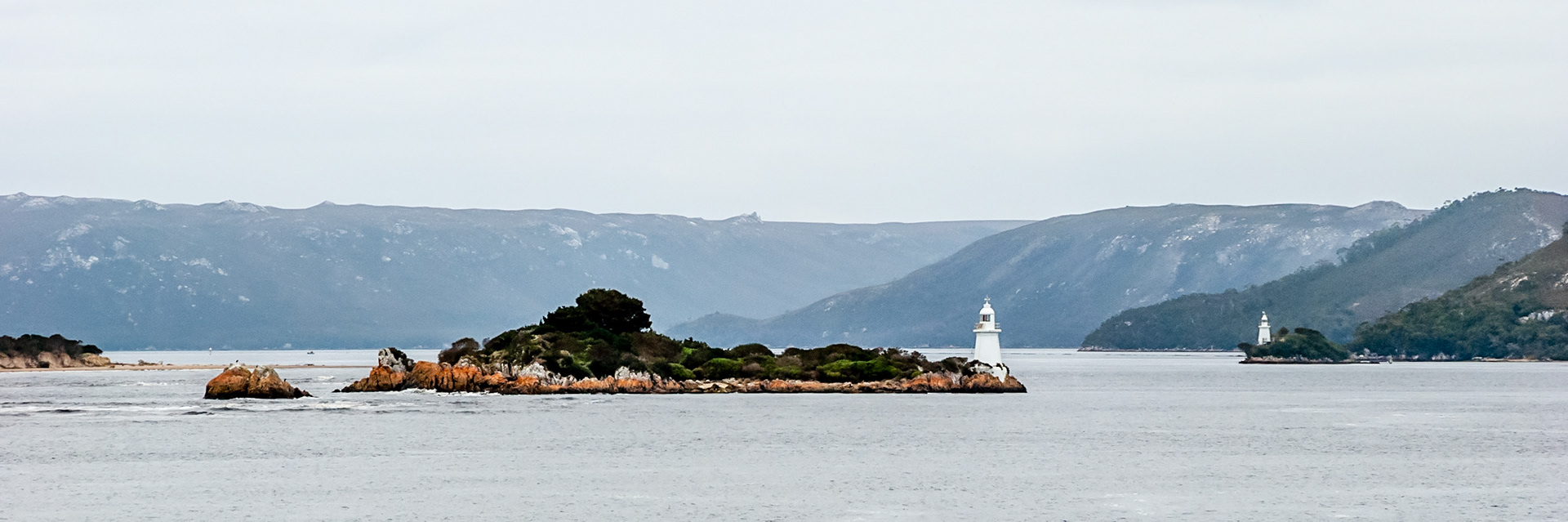 The Entrance Island and Bonnet Island Lighthouses stand at the entrance to Macquarie Harbour, a huge inland sea on the wild west coast of Tasmania.