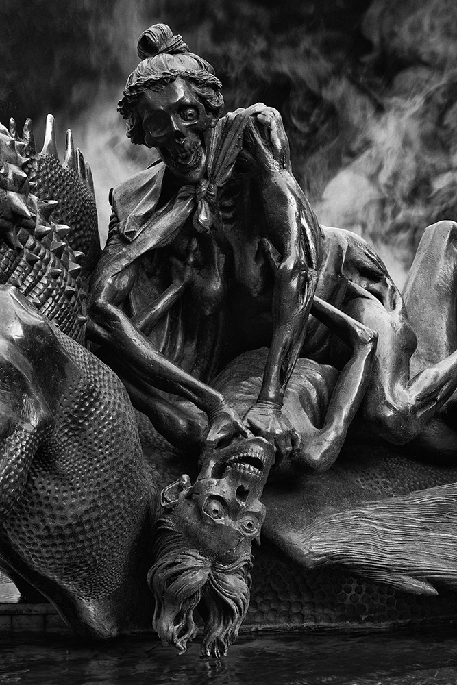 An elderly couple, half-skeletonized, wrestle with each other in a death struggle at a city fountain in Nuremberg.